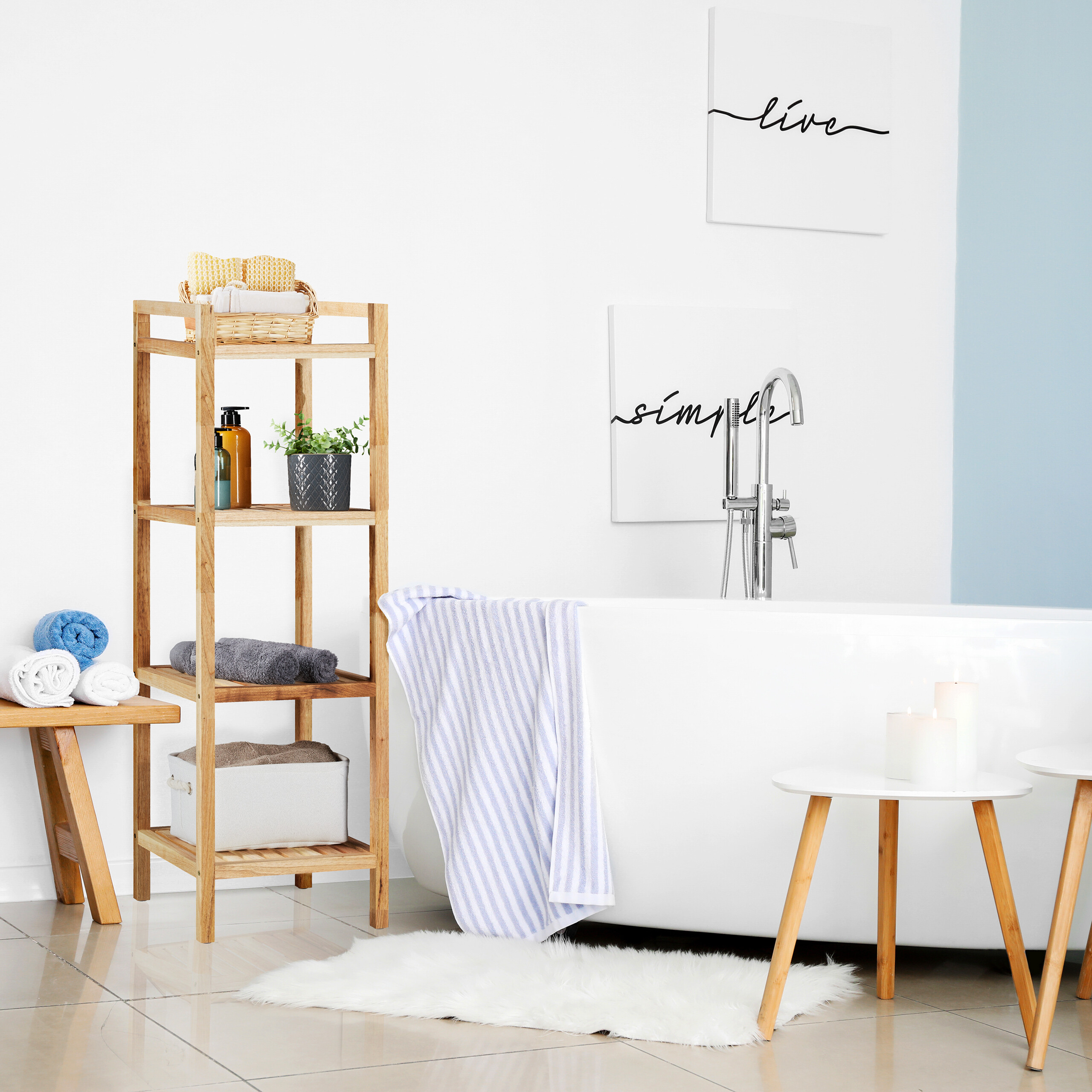 Moderne weiße Badewanne mit Holzdunst, Handtuchregal und Dekokissen im hellen Badezimmer.