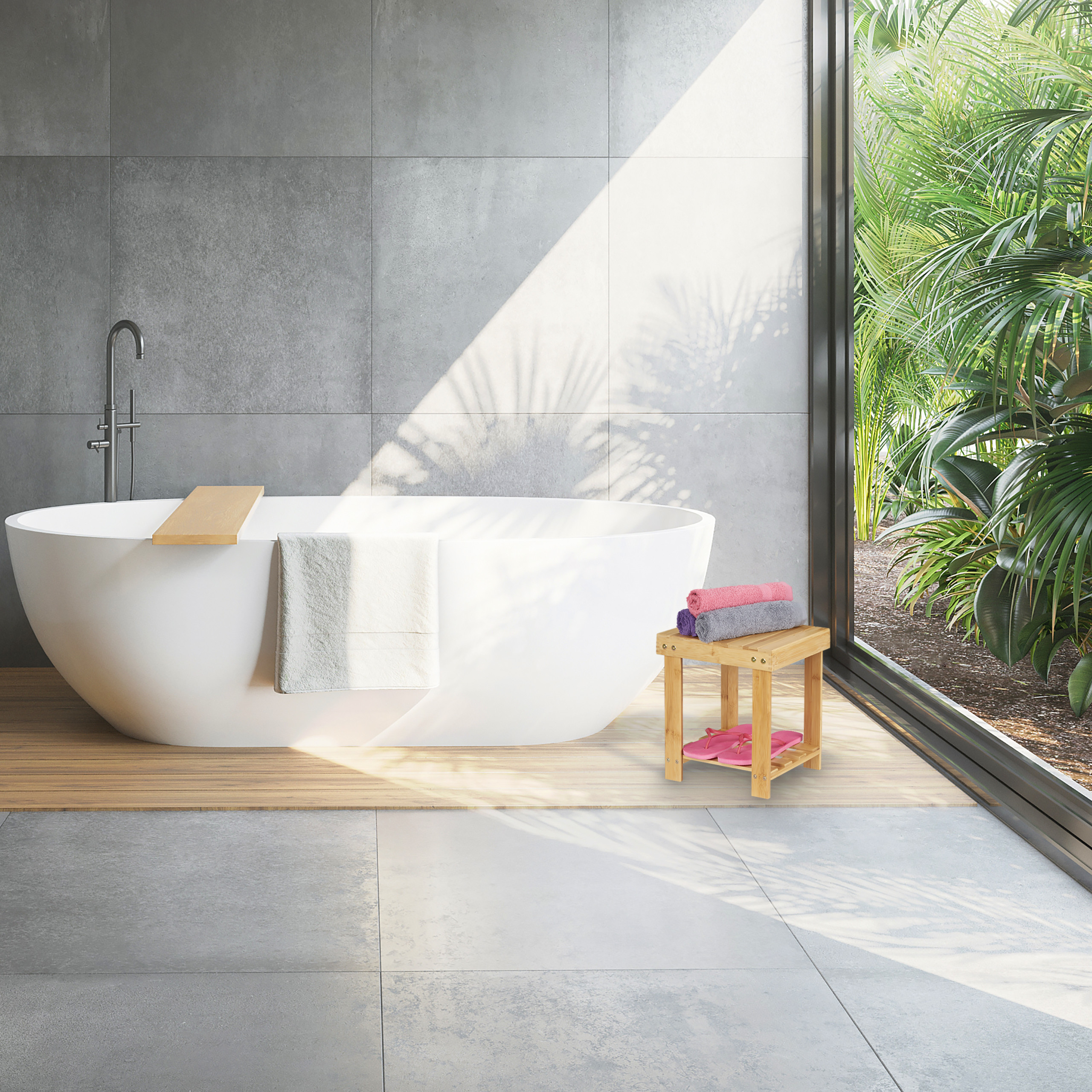 Moderne Badewanne mit Handtuch auf Holzpodest vor grauem Stein und großen Fenstern mit Palmenblick.