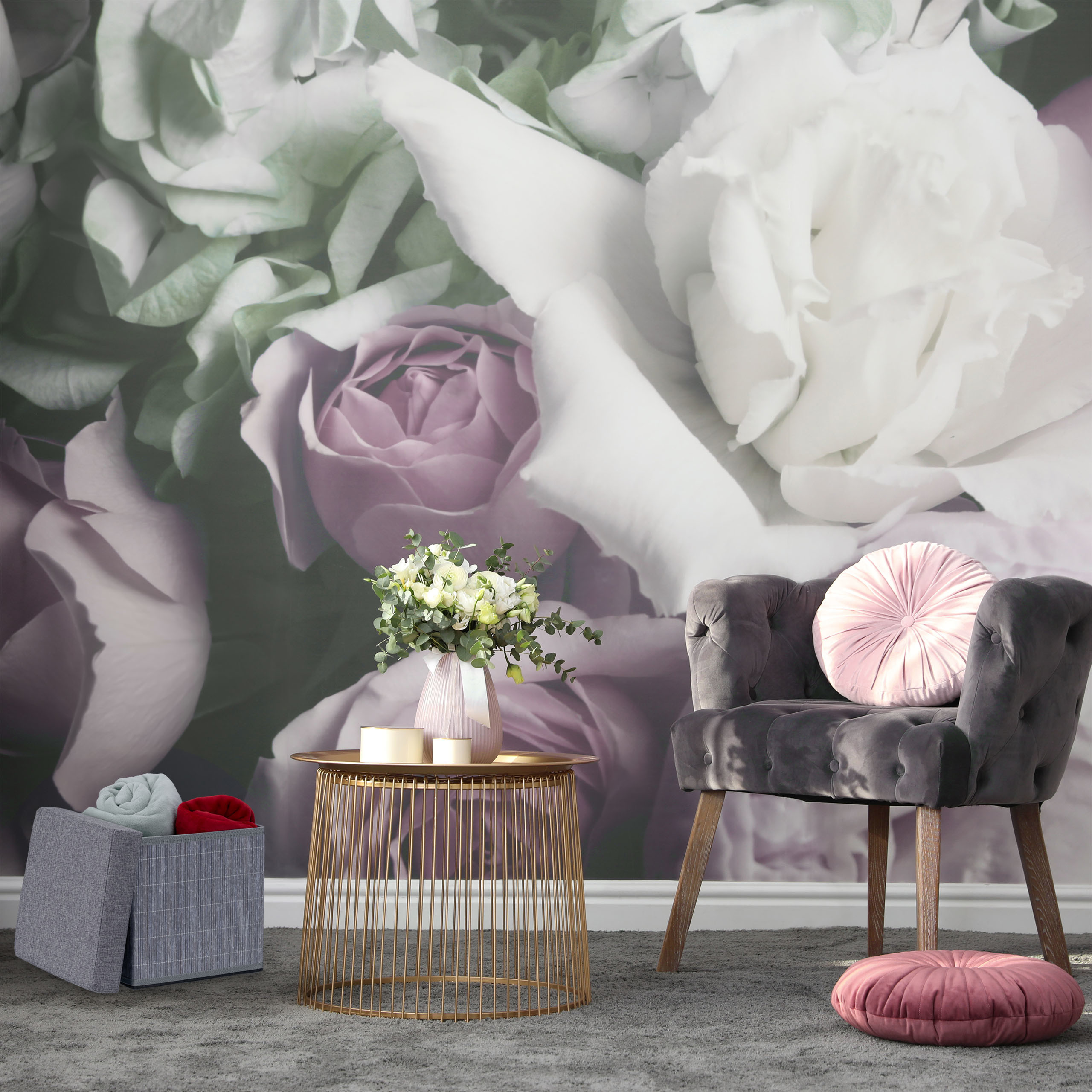 Grauer Sessel, runder Goldtisch mit Blumen und Kissen vor einer großen Rosen-Fototapete.