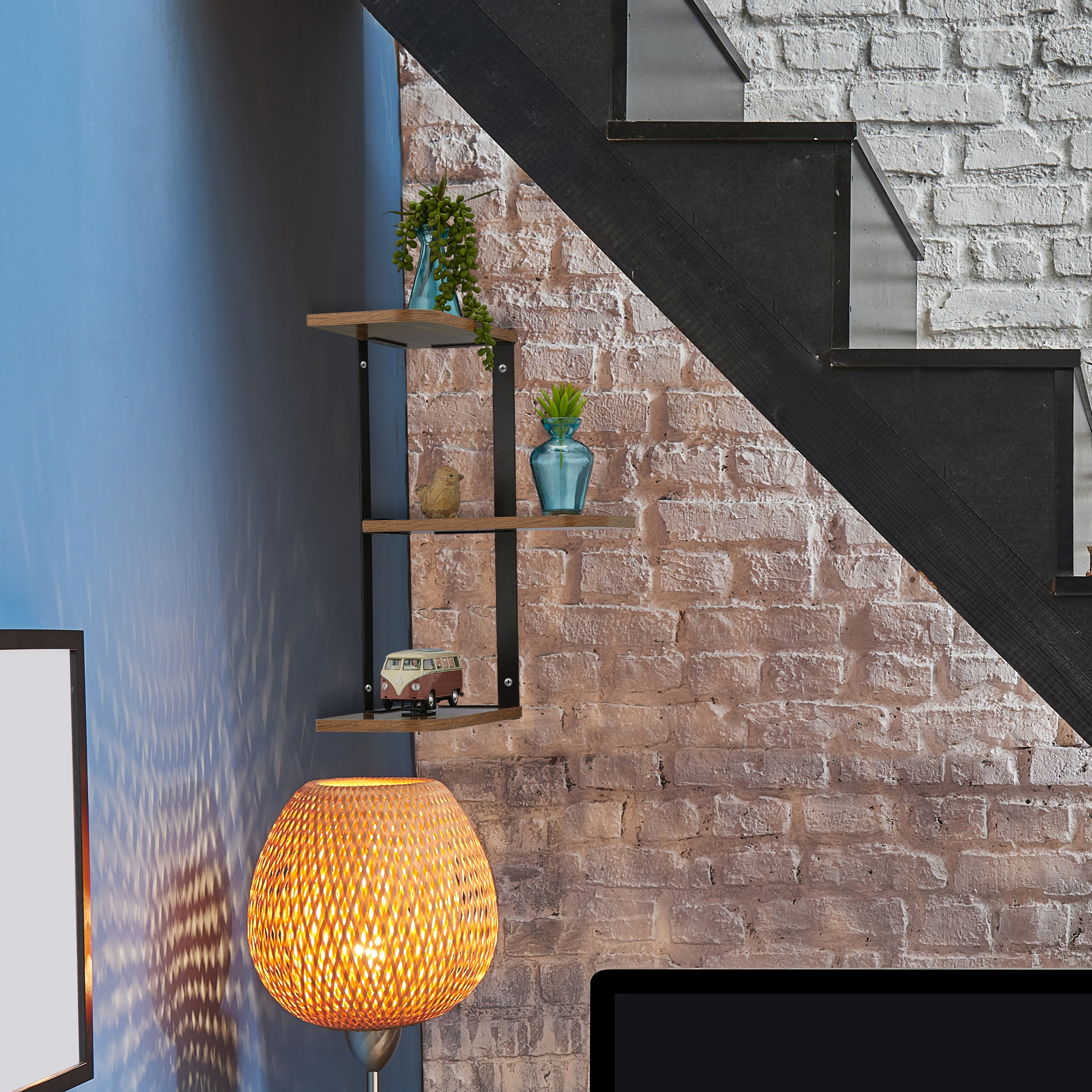 Wandregal mit Dekoration unter Treppe, beleuchtet von einer Lampe.