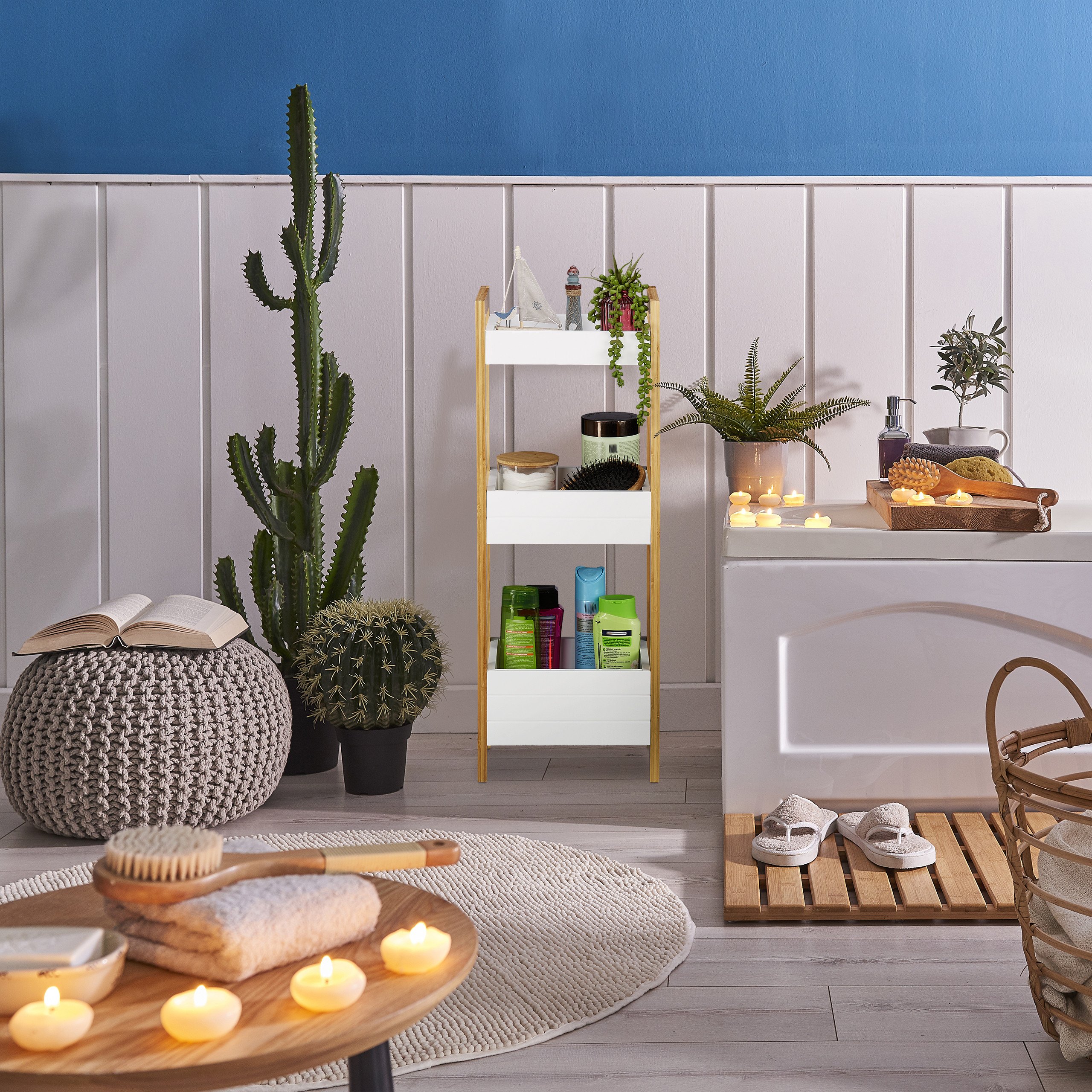 Gemütliches Badezimmer mit Pflanzen, Kerzen, einem Regal und einer Strickpouf mit offenem Buch.