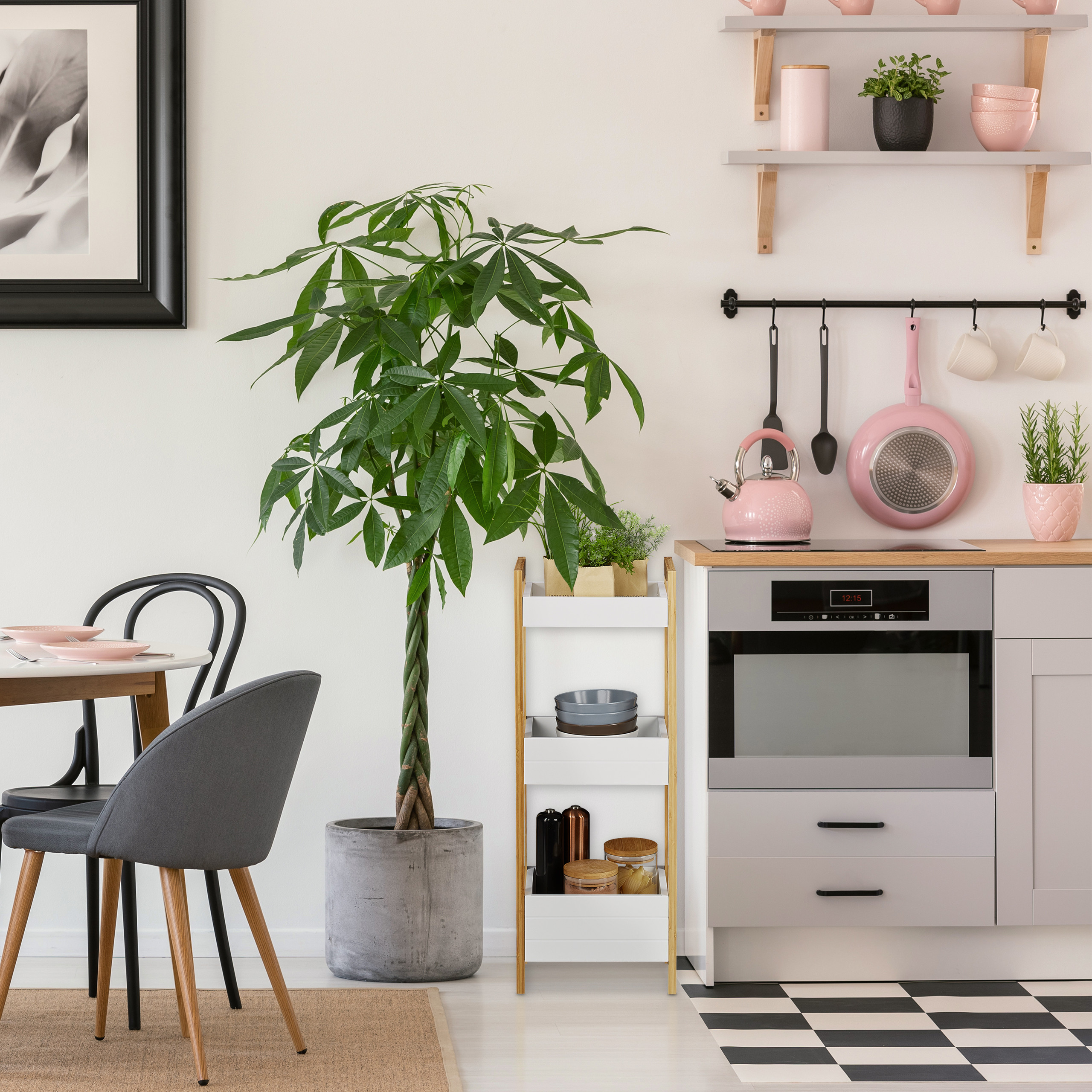 Moderne Küche mit rosa Kochgeschirr, einer großen Pflanze im Topf und einer angrenzenden Essecke mit grauen Stühlen.