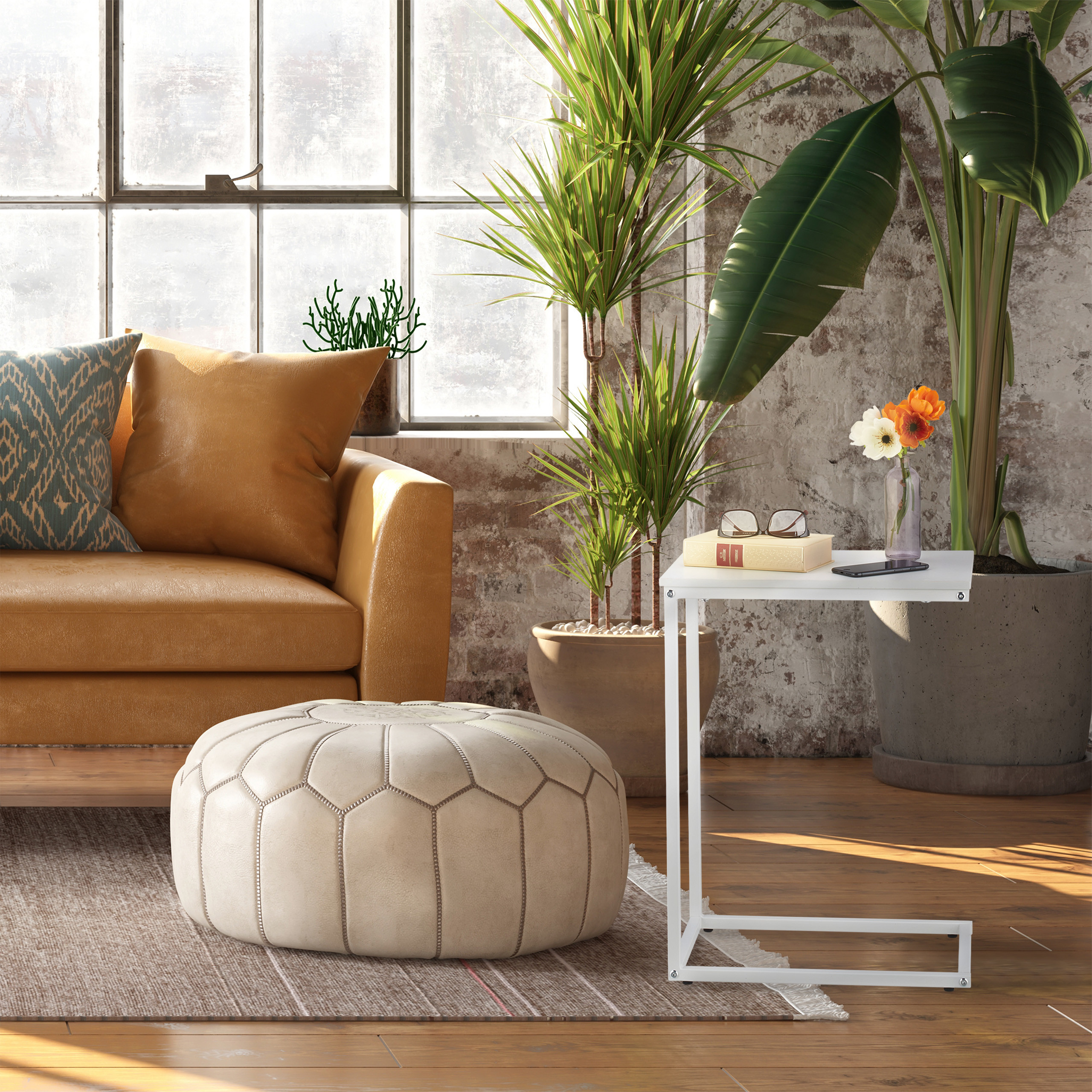 Lichter Wohnraum mit gelbem Sofa, weißem Tisch, Pouf und Pflanzen vor großen Fenstern.