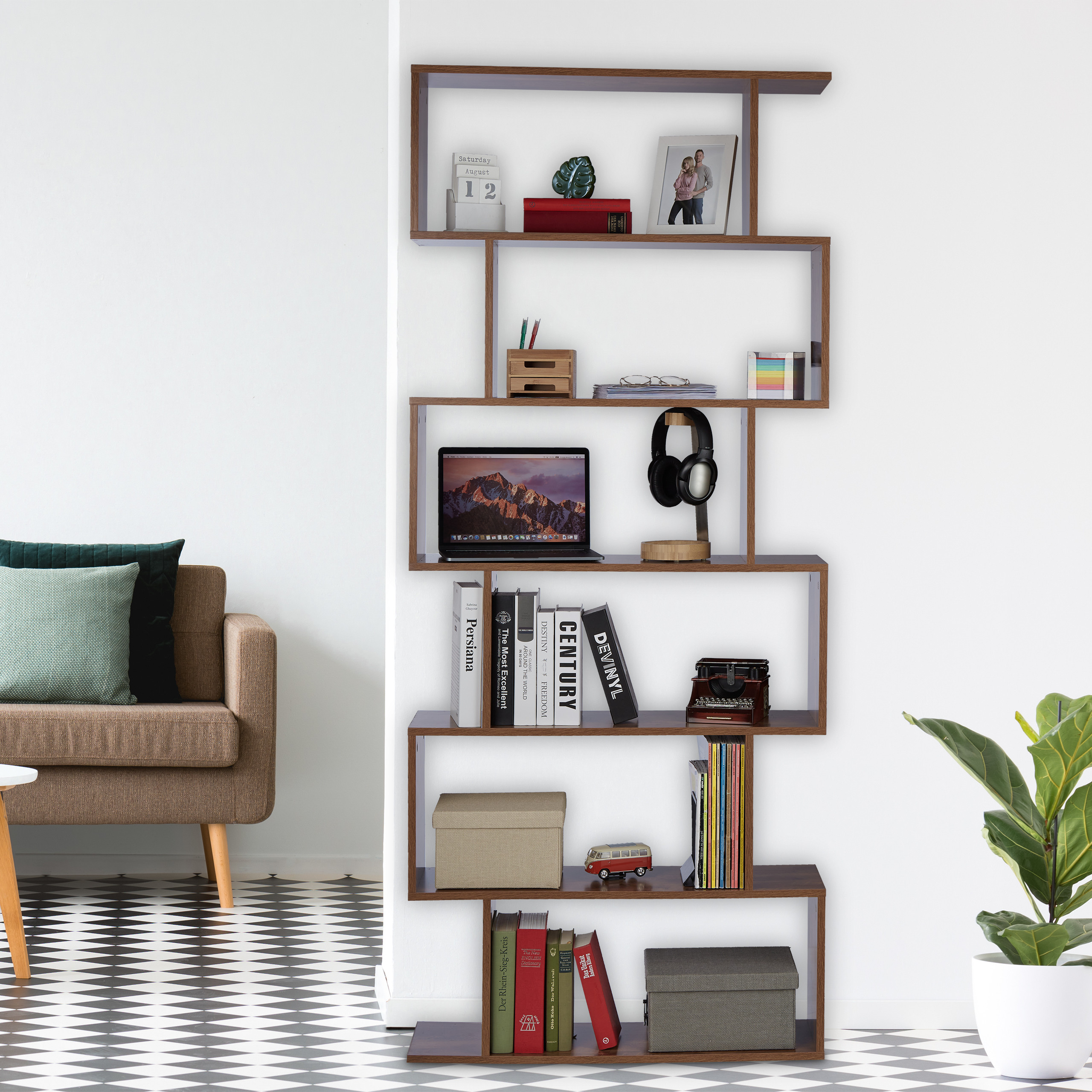 Ein modernes, offenes Holzregal steht an einer weißen Wand. Es enthält Bücher, Laptop, Kopfhörer und Dekoration.