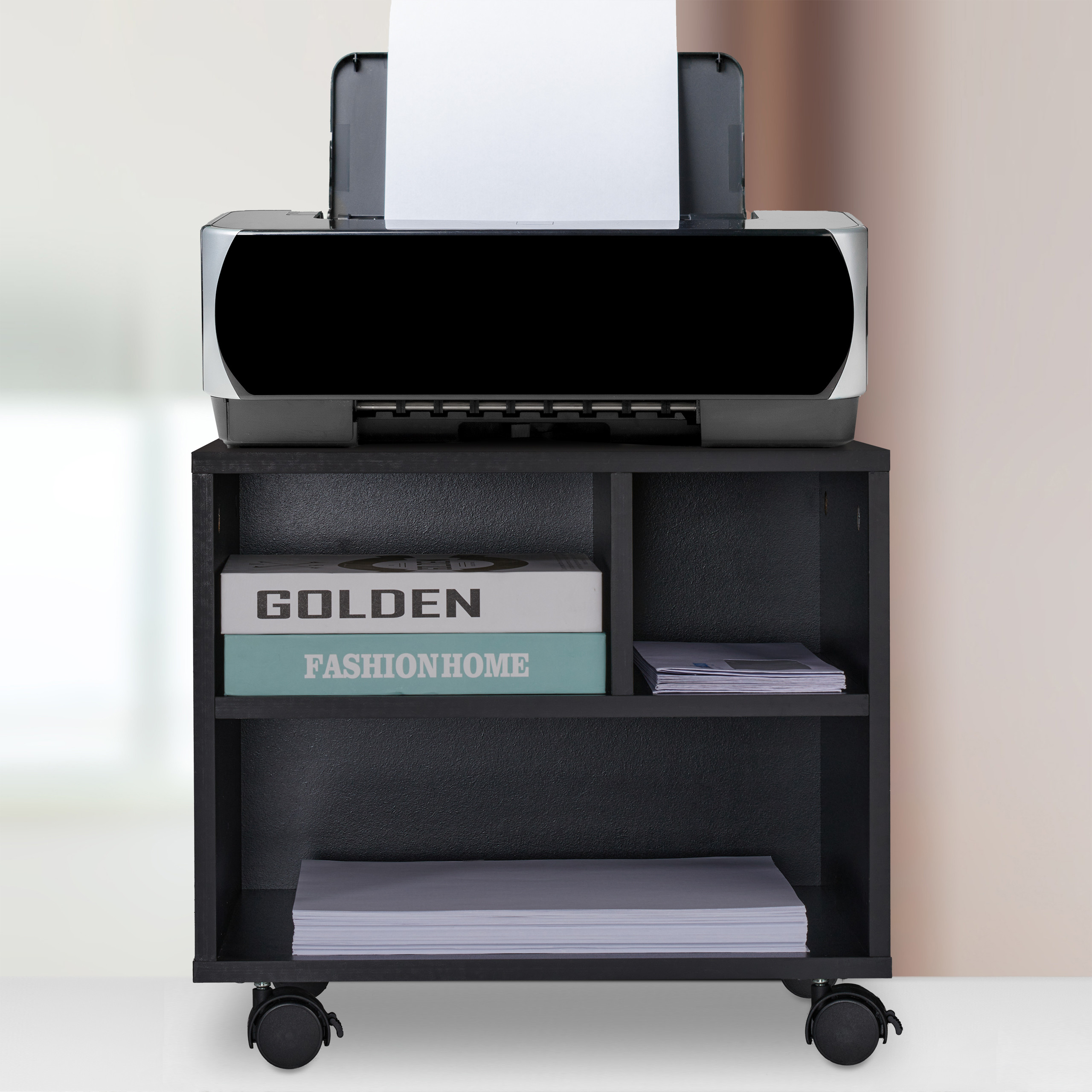 Ein schwarzer Drucker steht auf einem rollenden Schrank mit Büchern und Papier.