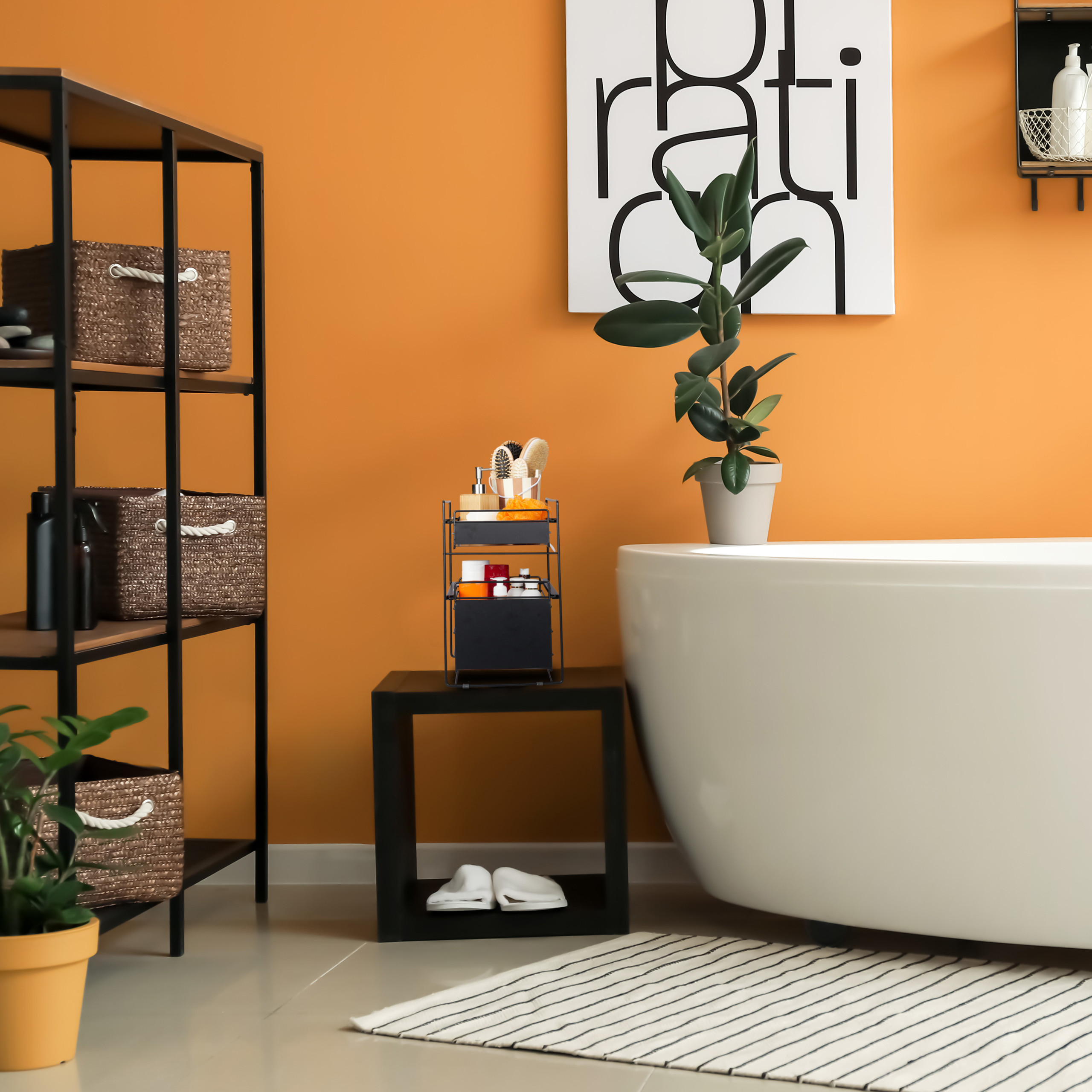 Ein modernes Badezimmer mit orangen Wänden, einer weißen Badewanne, einem Regal mit Körben und einer Pflanze.
