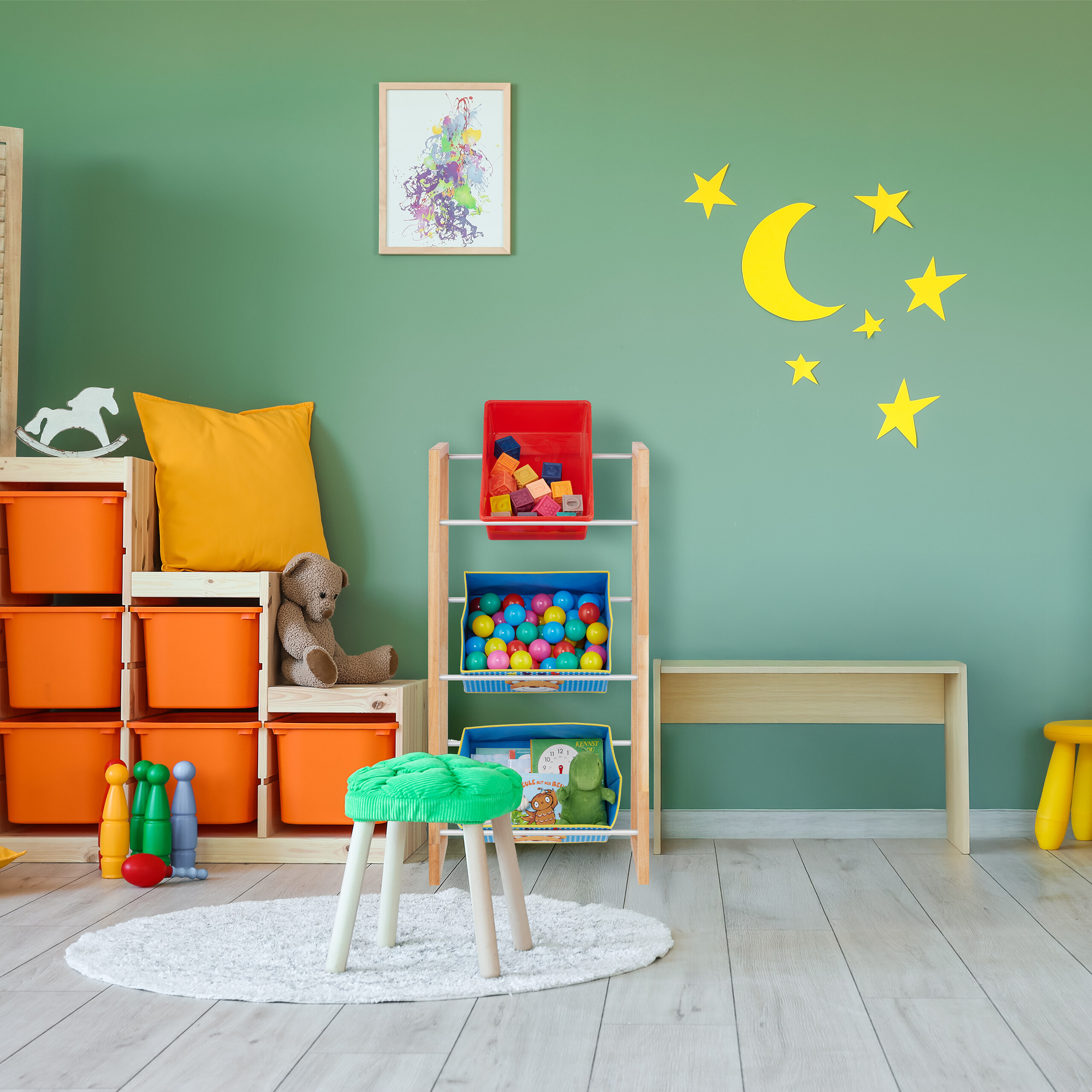 Ein Kinderzimmer mit grünen Wänden, gelben Mond- und Sternen-Wandtattoos, Spielzeugregalen und einem grünen Hocker.