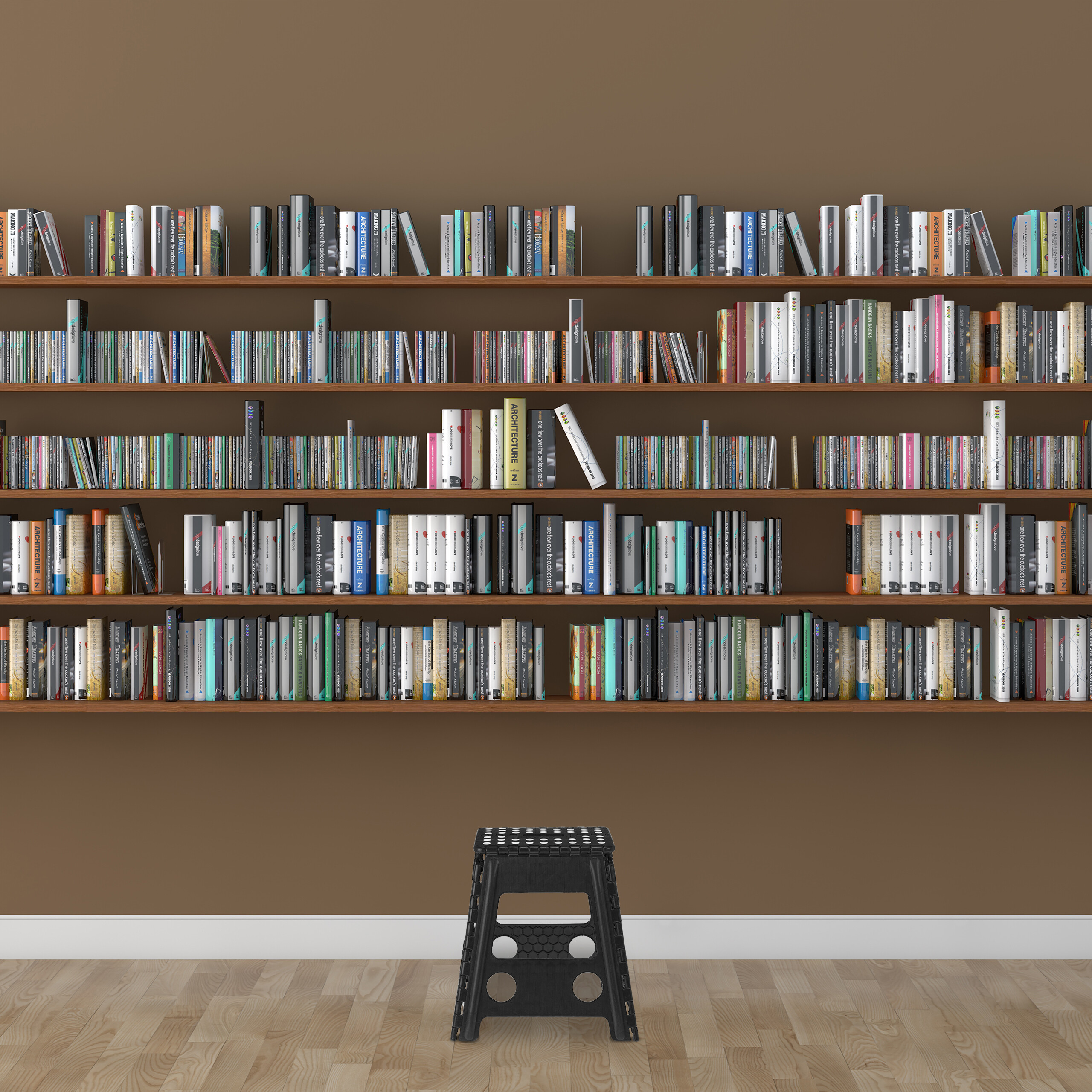 Ein Bücherregal voller farbiger Bücher und ein schwarzer Hocker auf Holzboden vor brauner Wand.