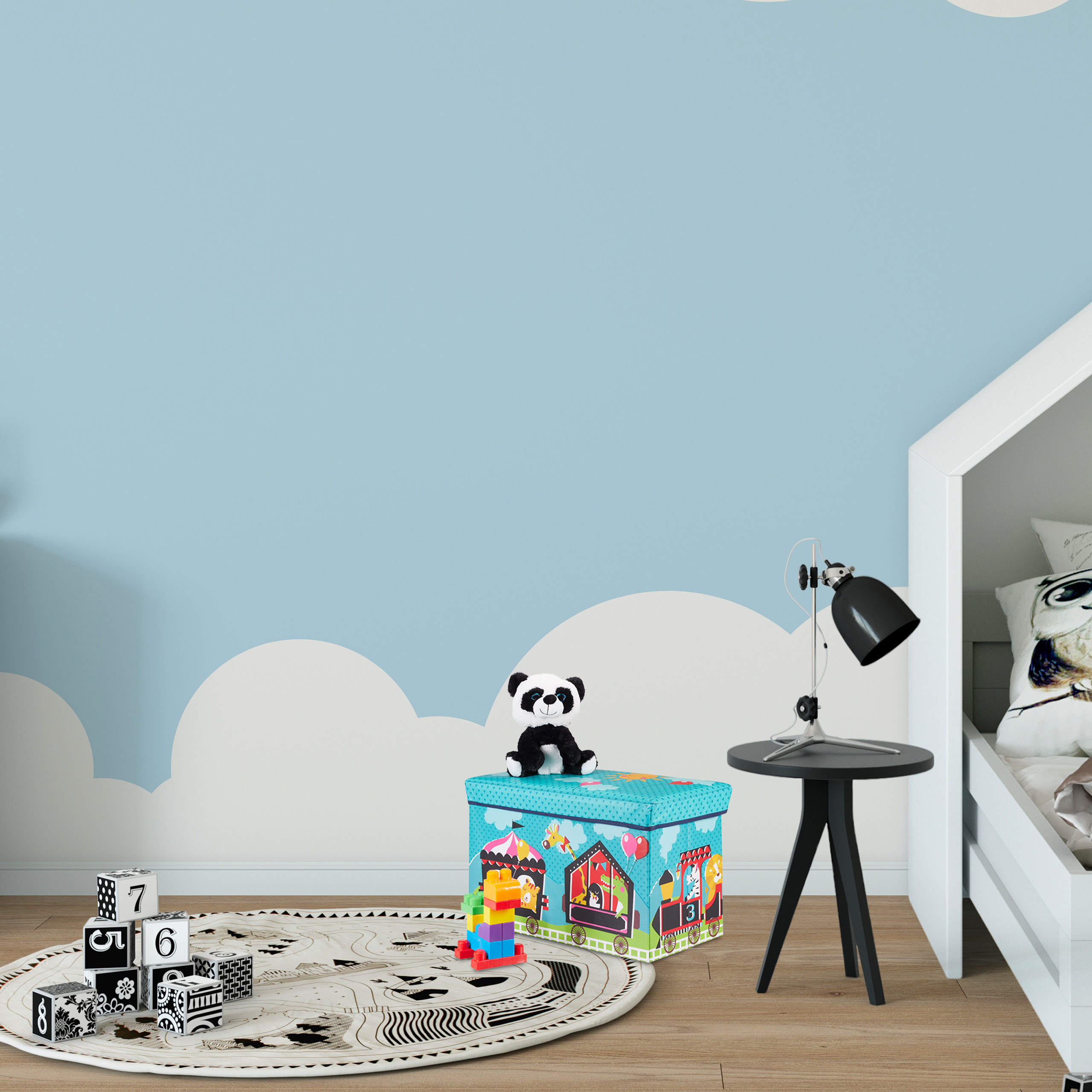 Kinderzimmer mit blauen Wänden, weißem Hausbett, Spielzeugkiste, Lampe, Klötzen und einem runden Teppich.