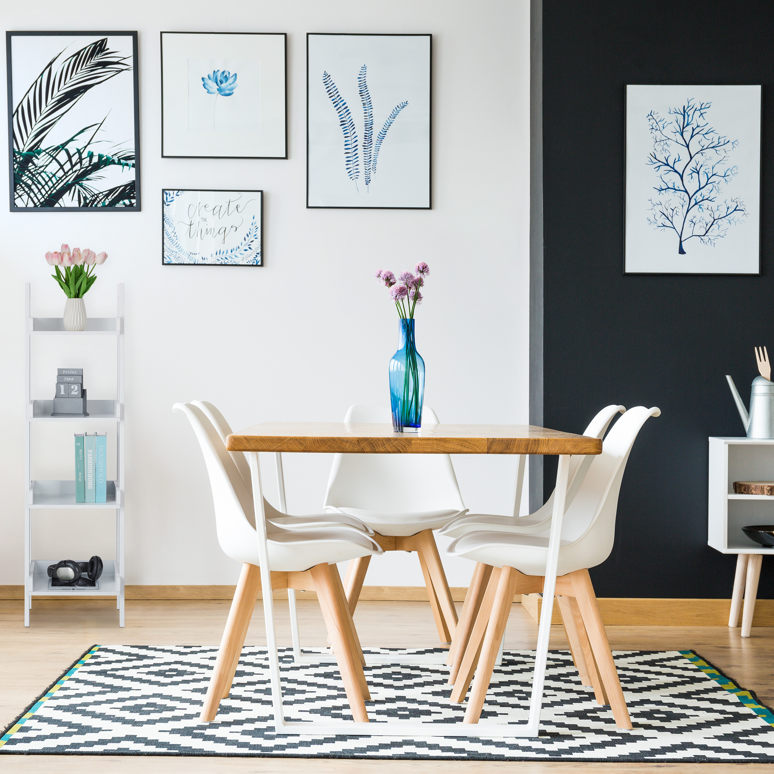 Moderne Esszimmereinrichtung mit Holztisch, weißen Stühlen und blauem Blumenmusterdekor an den Wänden.