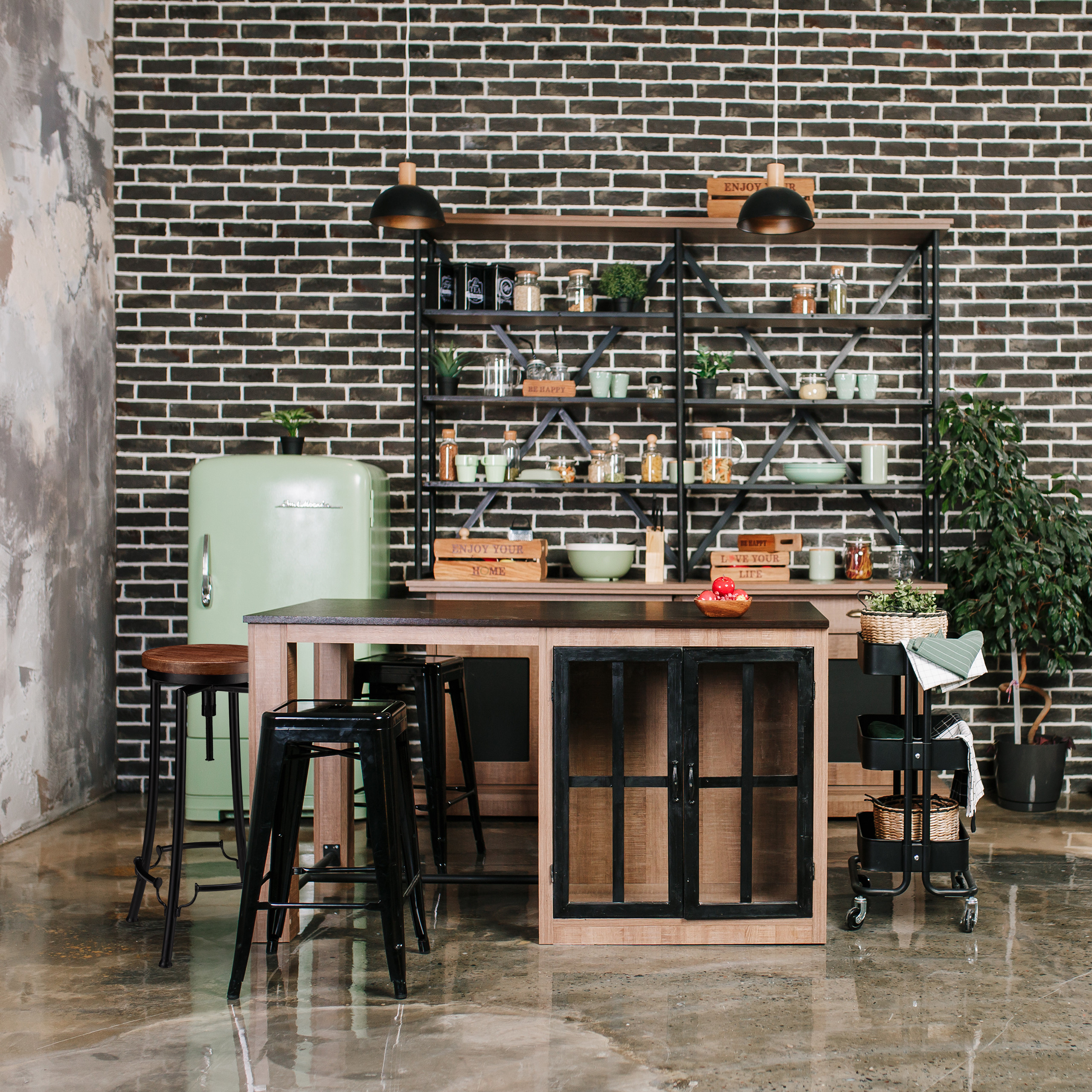 Eine moderne Industriekommission hat einen grünen Retro-Kühlschrank, dunkle Backsteinwände, Regale und eine Holzinsel.