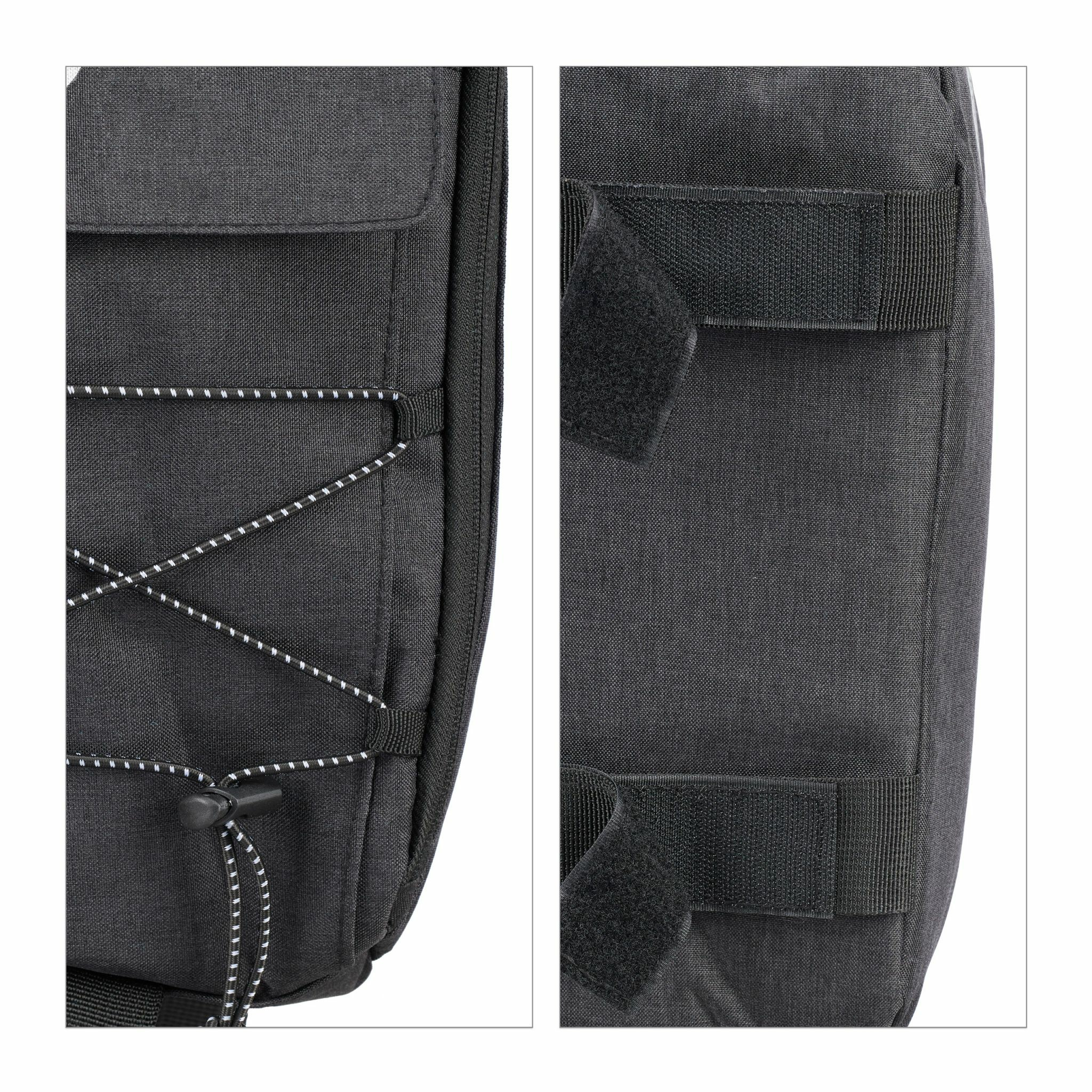 Nahaufnahme einer schwarzen Tasche mit elastischen Kordeln vorne und Klettverschlüssen hinten.
