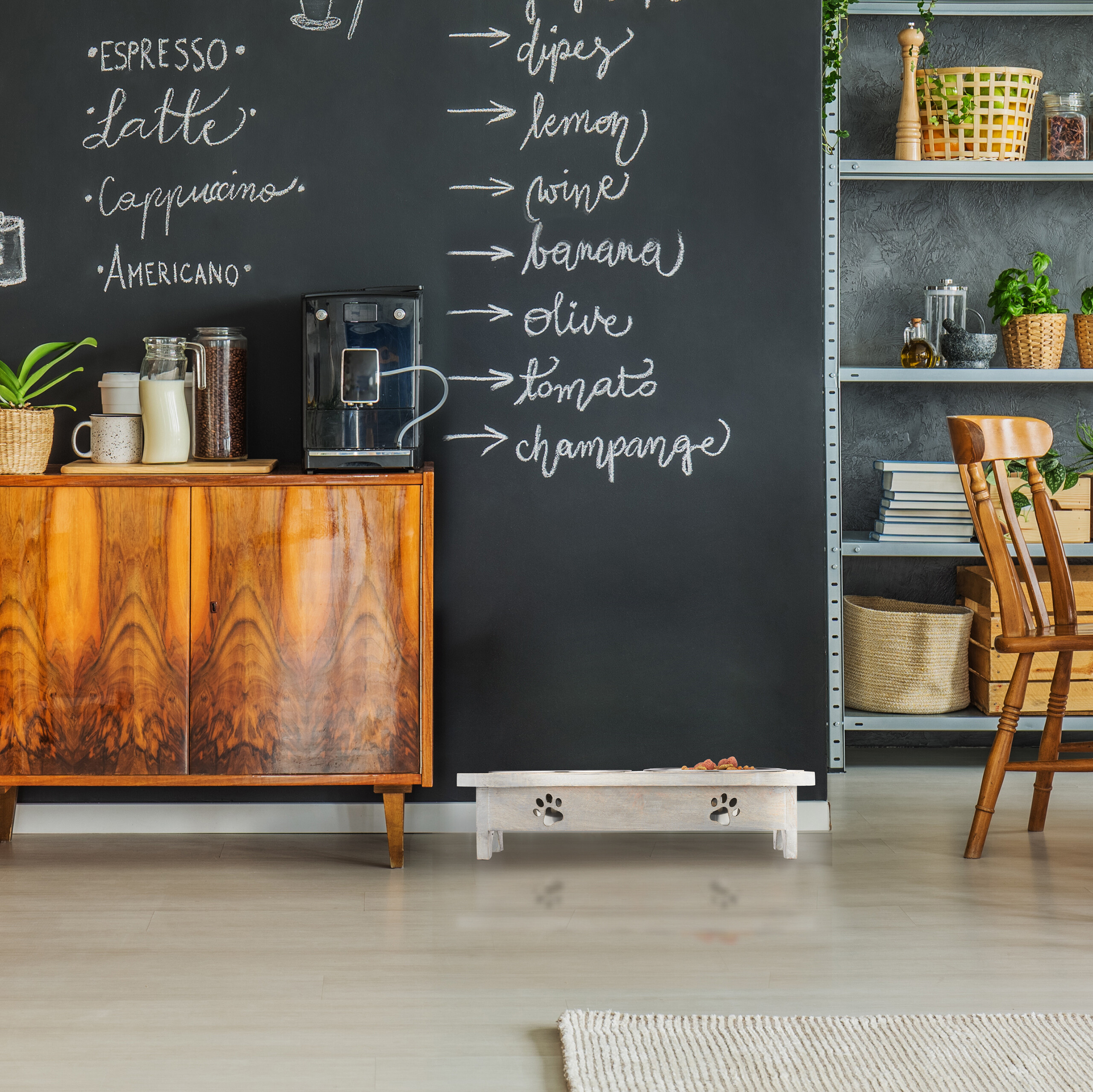 Holzkommode vor einer schwarzen Tafelwand mit Kaffeeliste, Kaffeemaschine und Regalen.