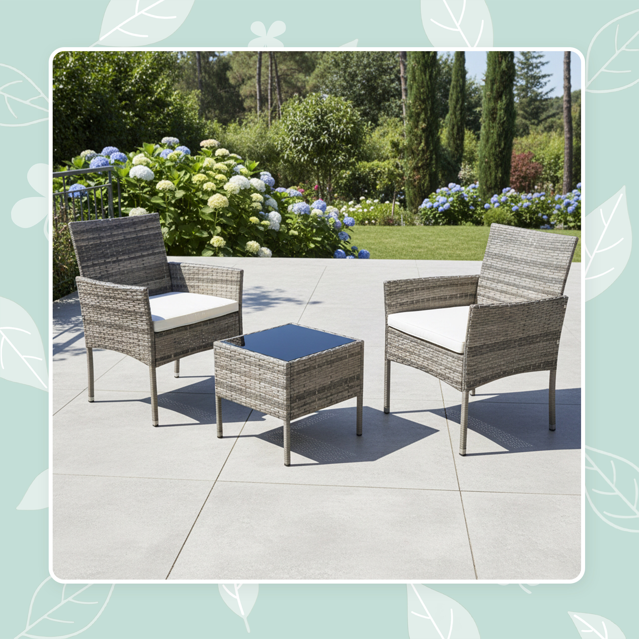 Graue Rattansessel mit weißen Kissen und kleiner Tisch auf einer Terrasse im Garten.
