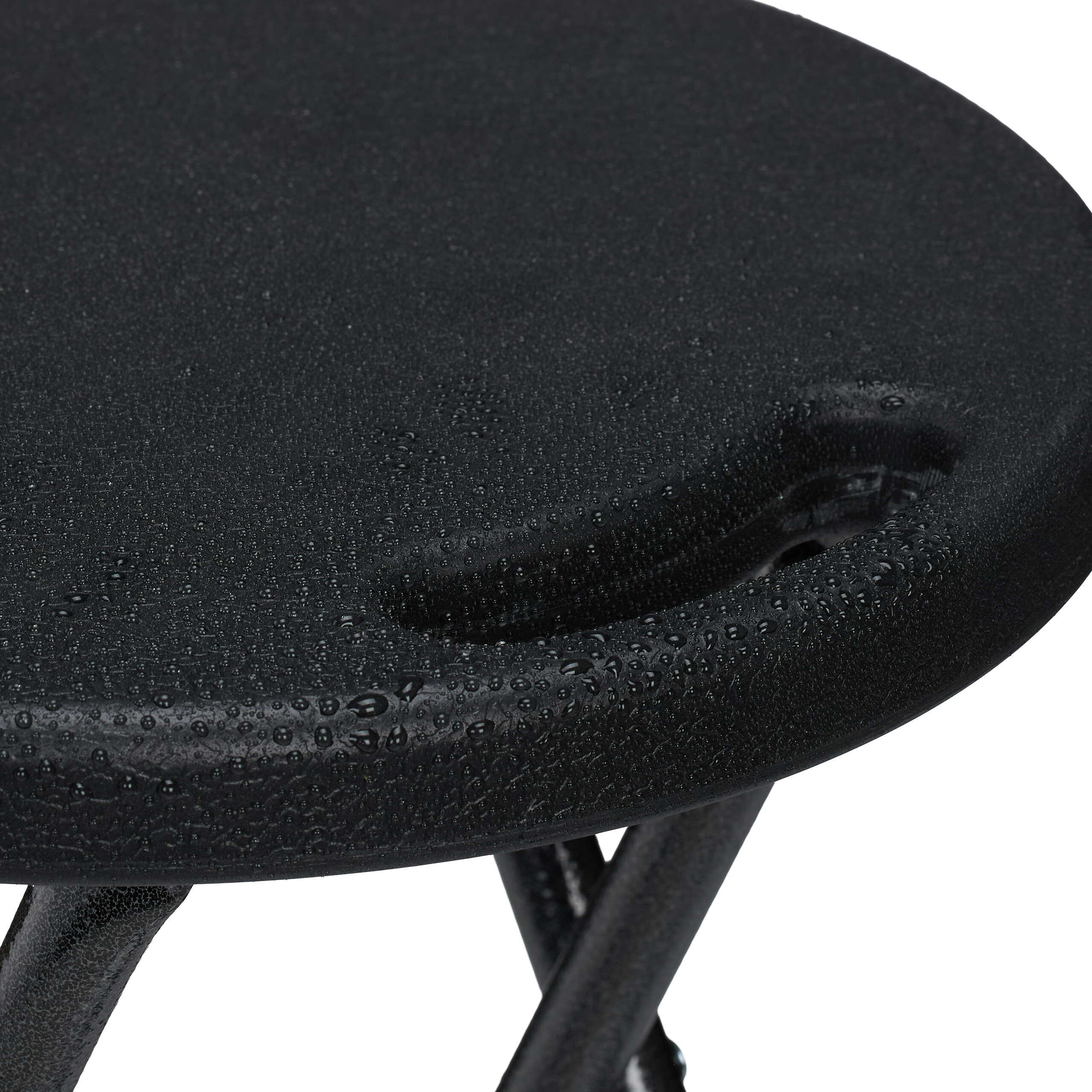 Schwarzer Klapphocker mit Wassertropfen auf der runden Sitzfläche.