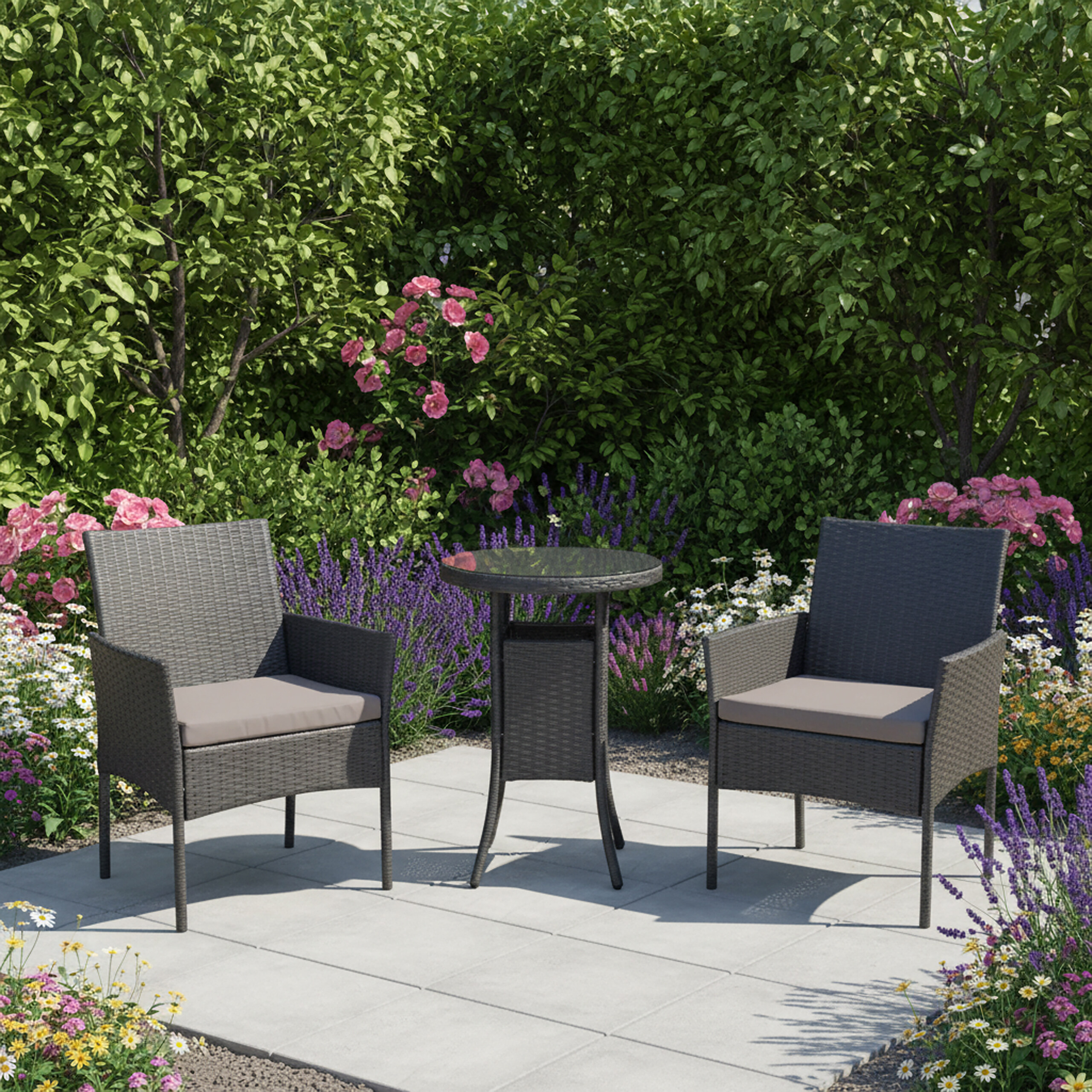 Zwei graue Polyrattan-Sessel und ein kleiner runder Tisch auf einer Steinterrasse, umgeben von bunten Blumen.