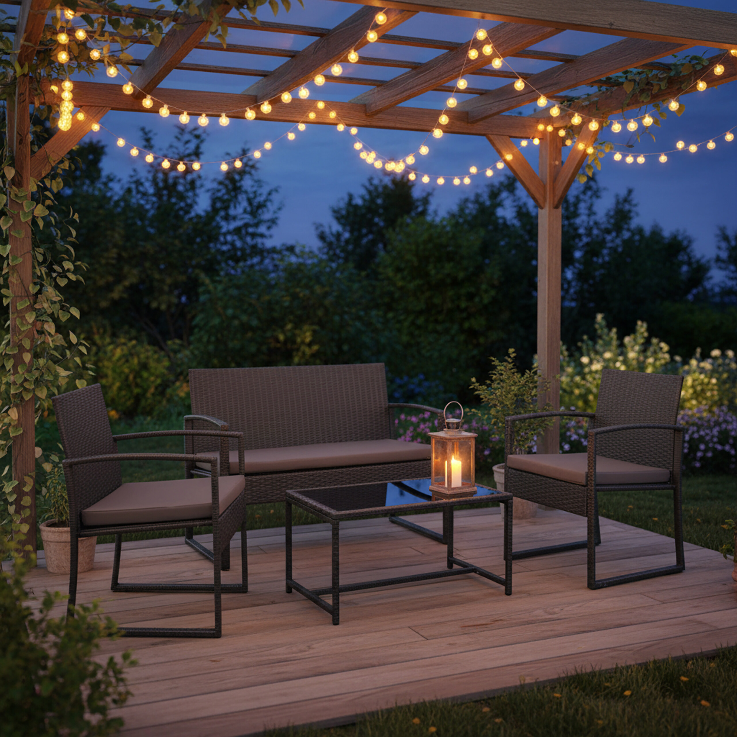 Eine gemütliche Holzdachterrasse bei Nacht mit Rattanmöbeln, Lichterketten und einer Laterne.