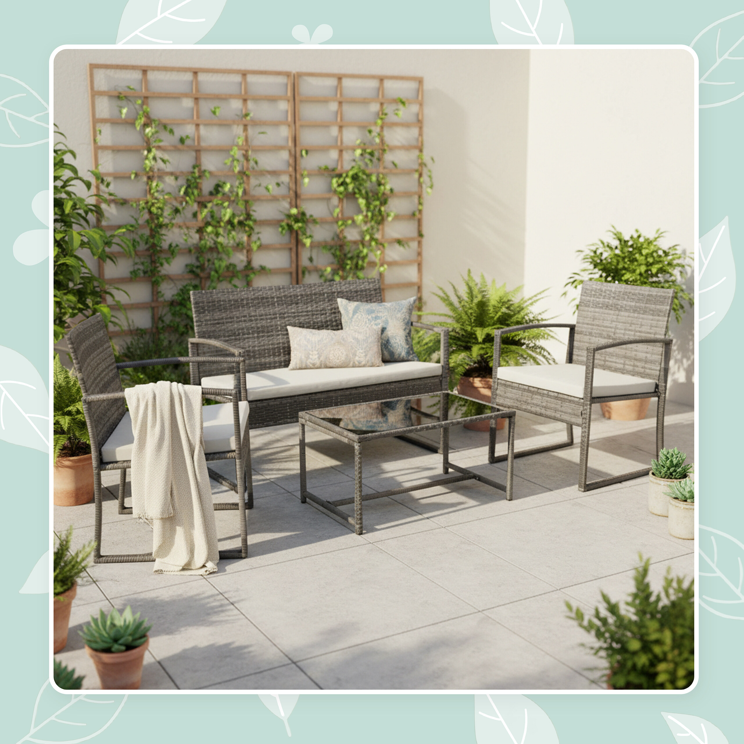 Graues Rattangartenmöbelset mit Tisch, Sofa und Sesseln auf einer Terrasse mit vielen Topfpflanzen.