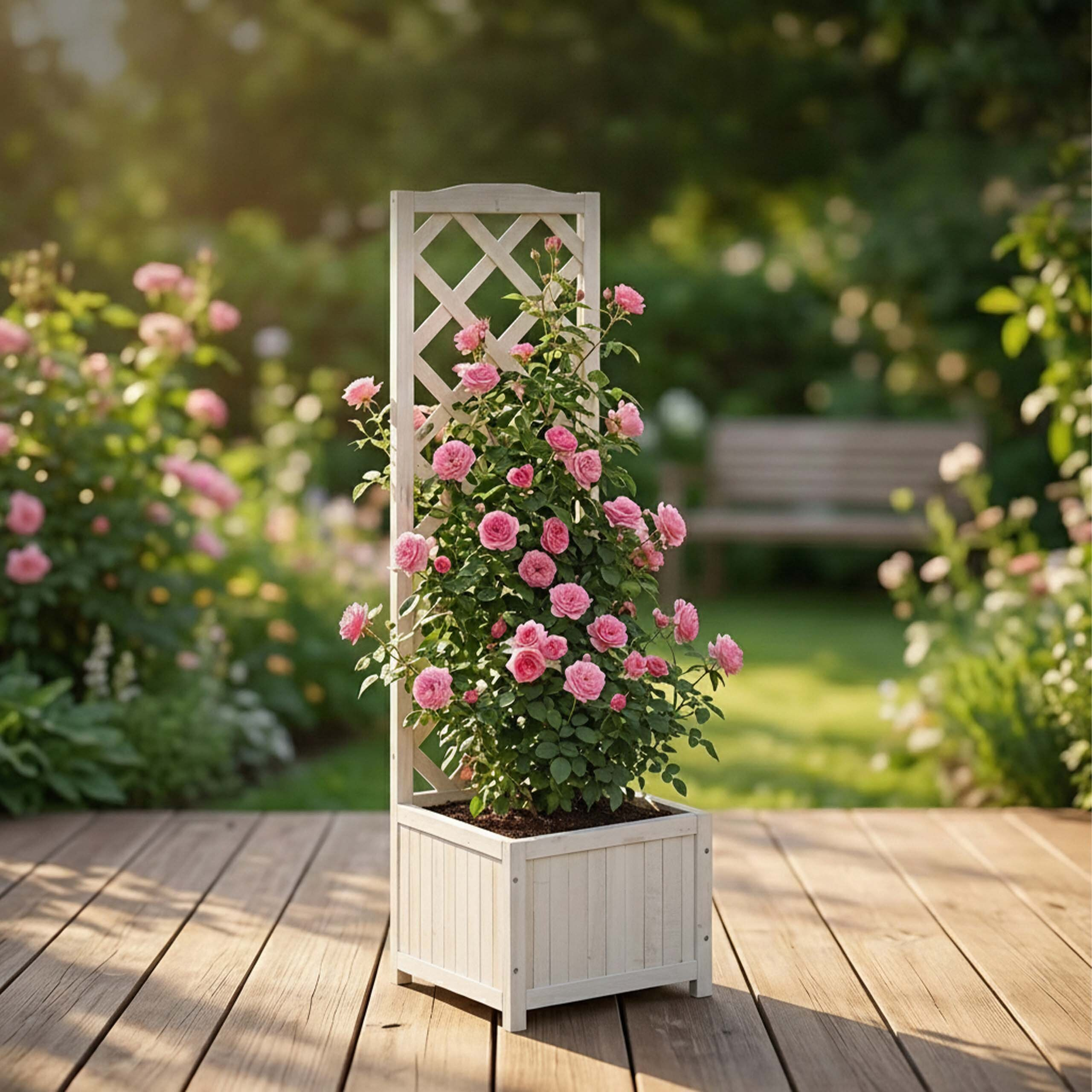 Ein weißer Pflanzkasten mit Spalier und blühenden rosa Rosen steht auf einer Holzterrasse im Garten.