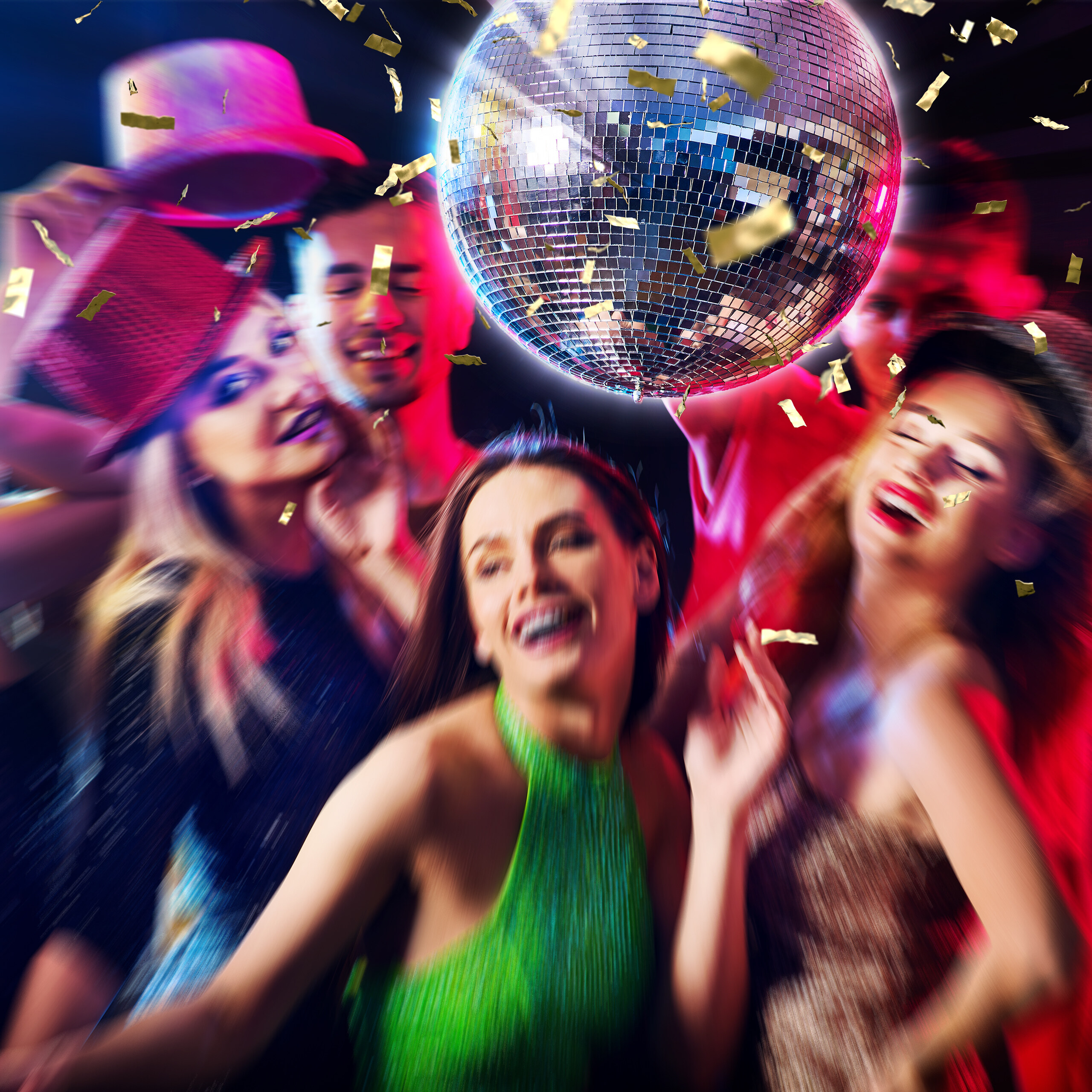 Freudige Menschen feiern unter einer glänzenden Discokugel mit fallendem Konfetti.