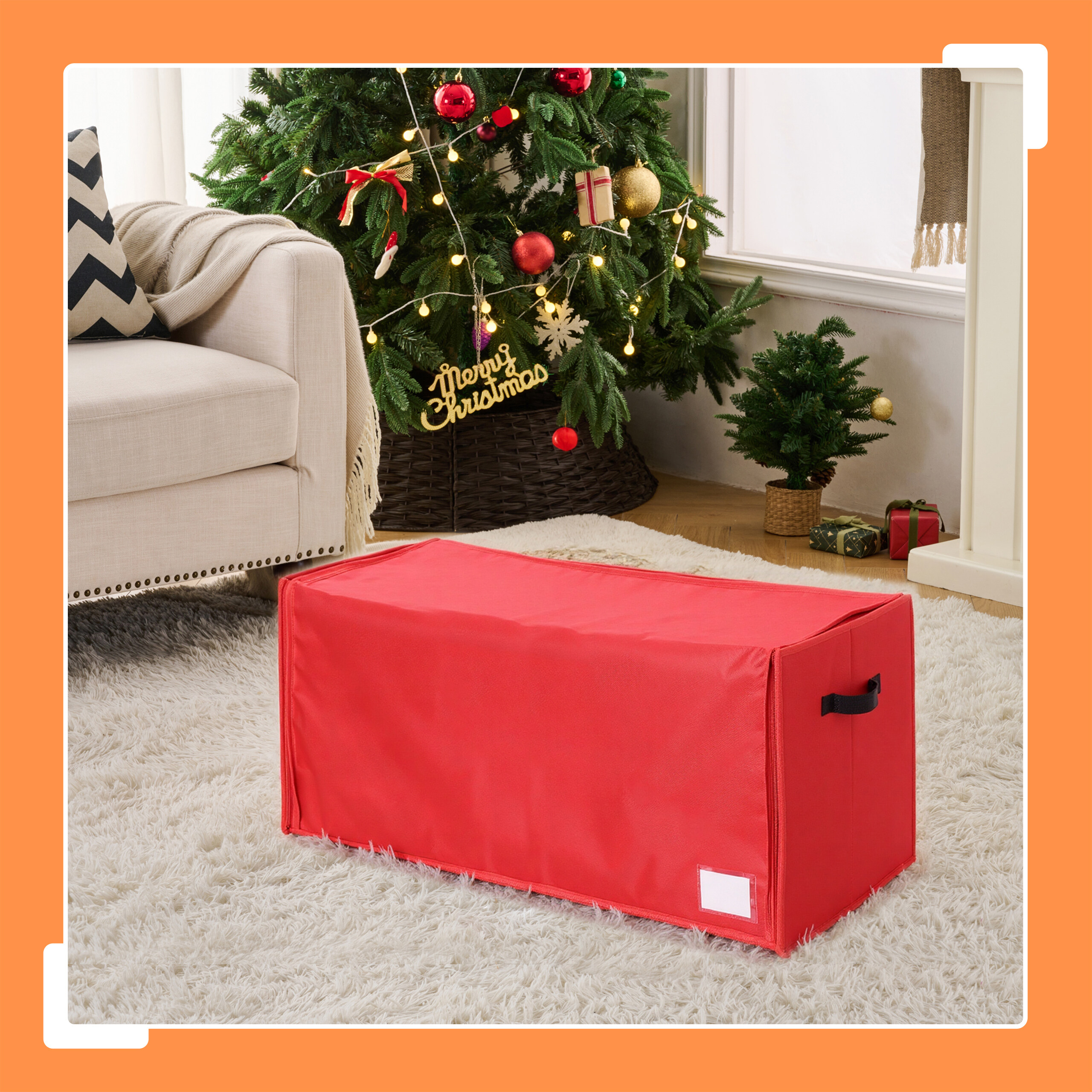Eine große rote Aufbewahrungsbox steht auf einem weißen Teppich in einem weihnachtlich geschmückten Wohnzimmer.