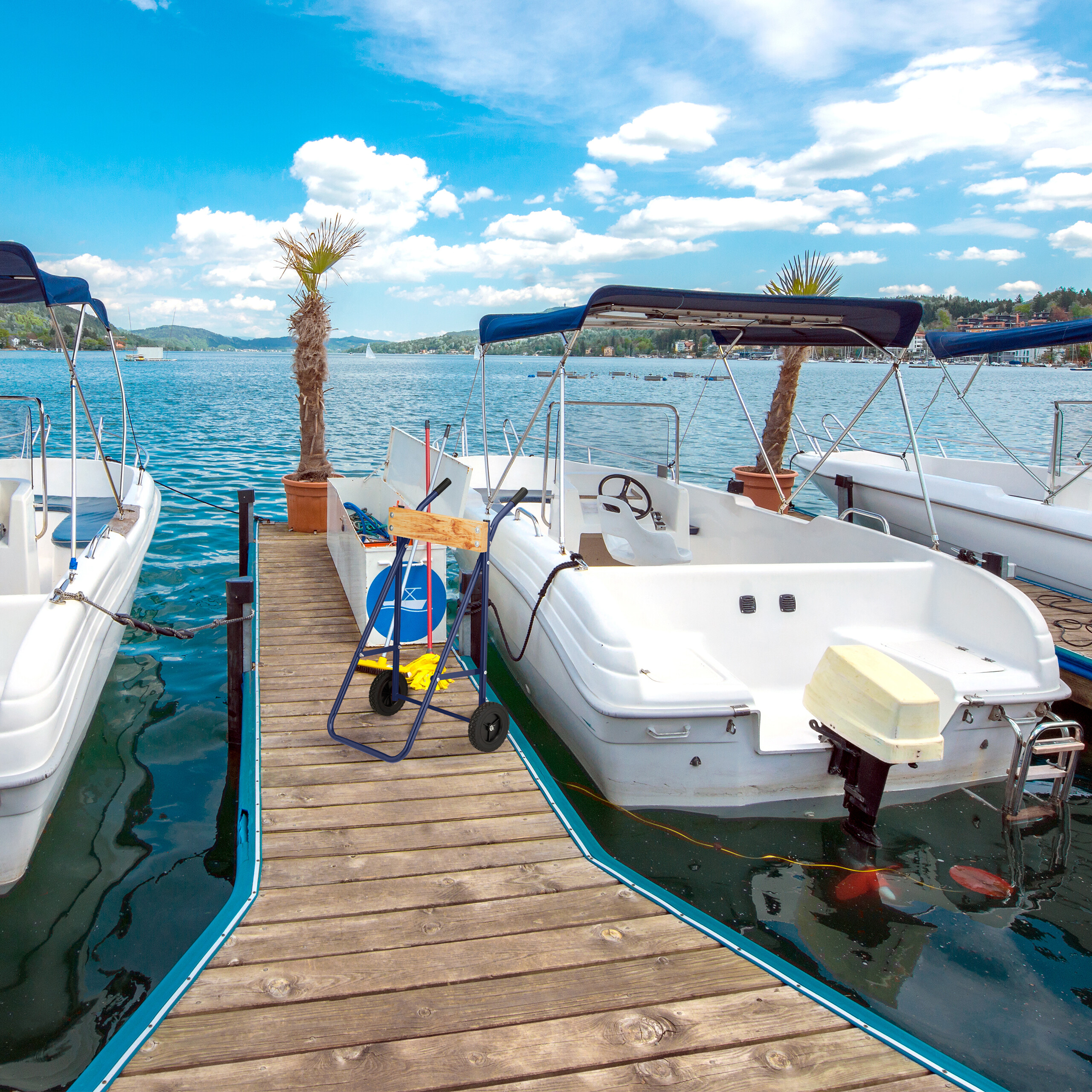Weiße Motorboote am Holzsteg an einem sonnigen See mit blauem Himmel.