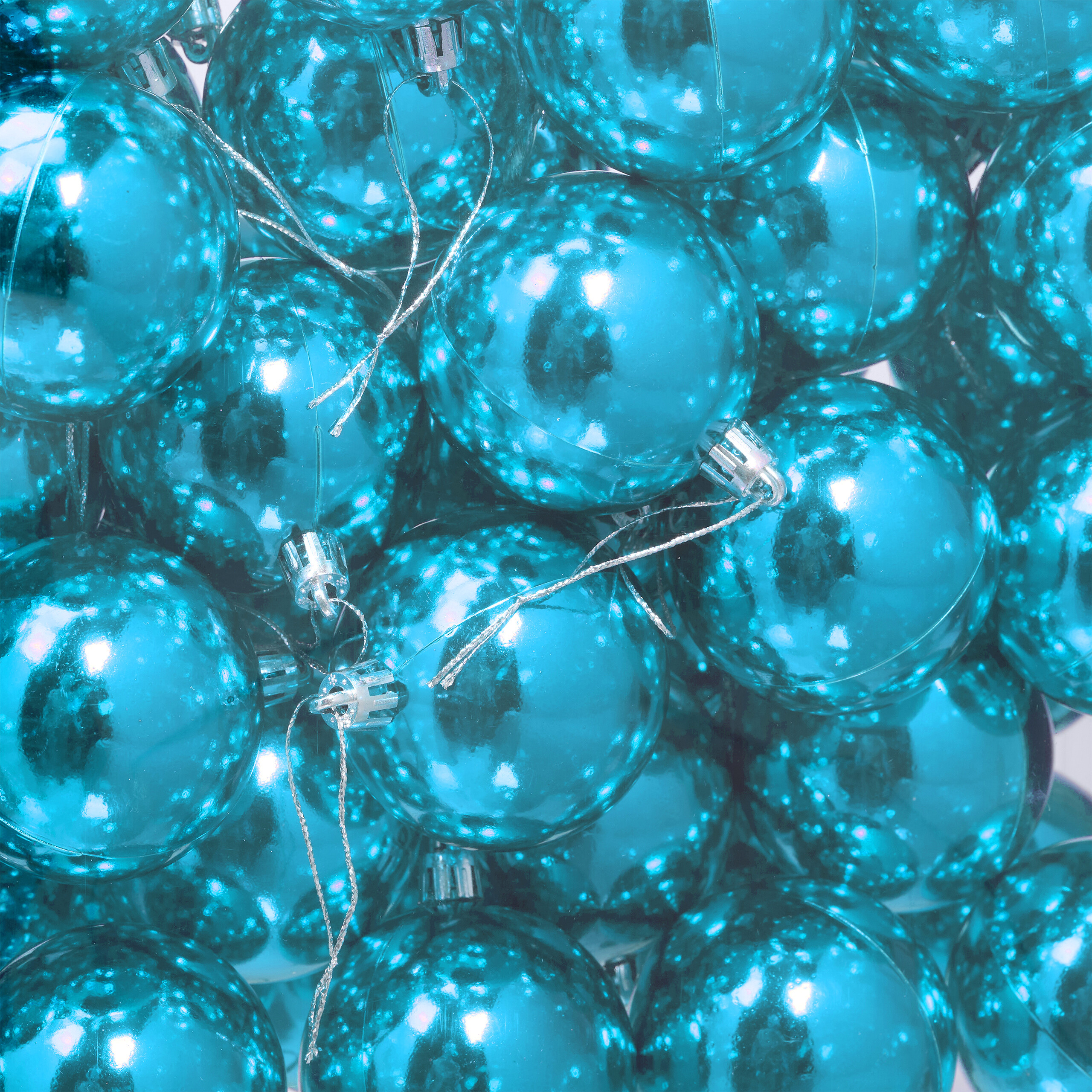 Eine Ansammlung glänzender, blauer Weihnachtskugeln mit silbernen Bändern.