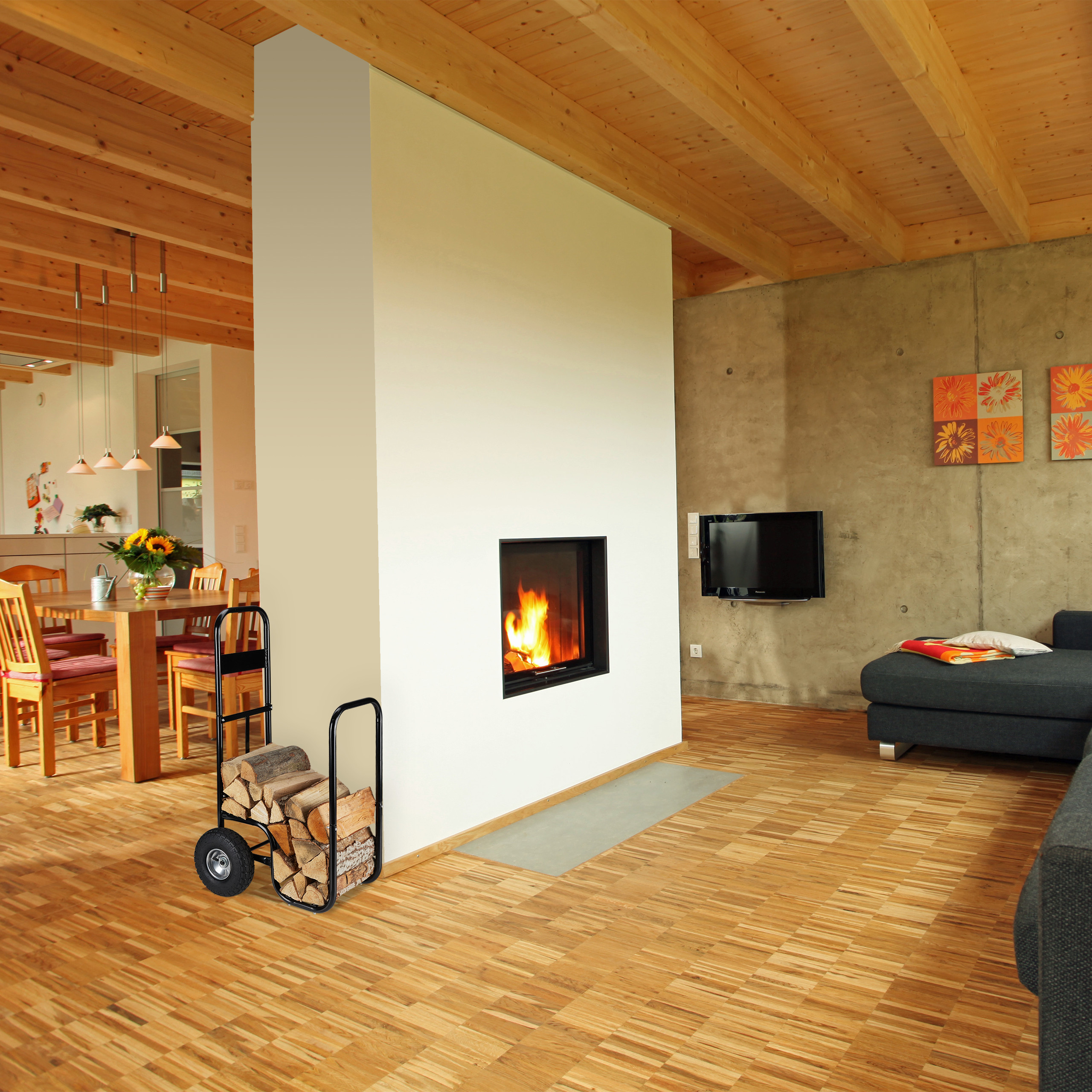Gemütliches Wohnzimmer mit Holzbalkendecke, Kamin in einer weißen Wand, Holztisch und Sofa.