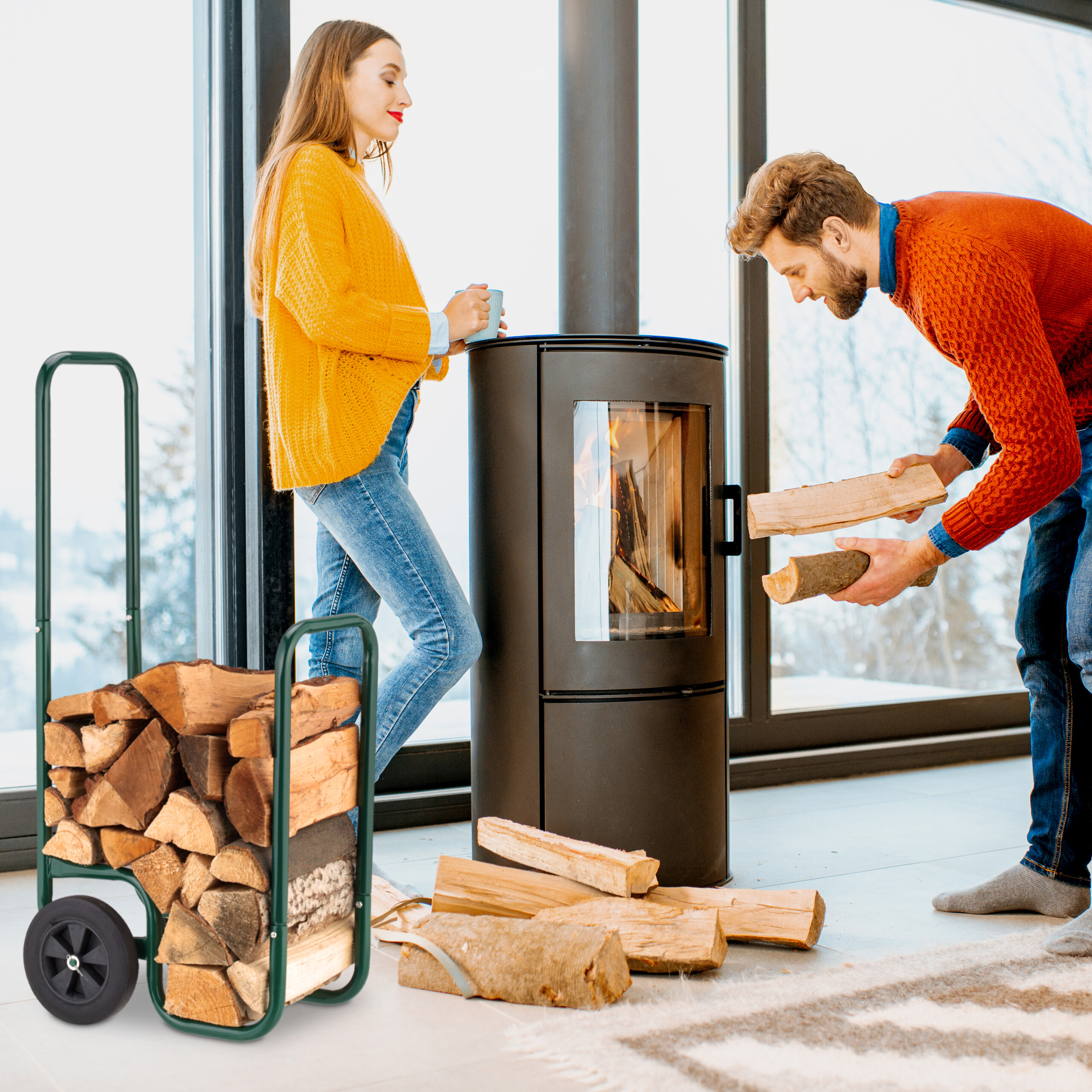 Ein Mann legt Holz in einen Kamin, während eine Frau mit einer Tasse daneben steht.