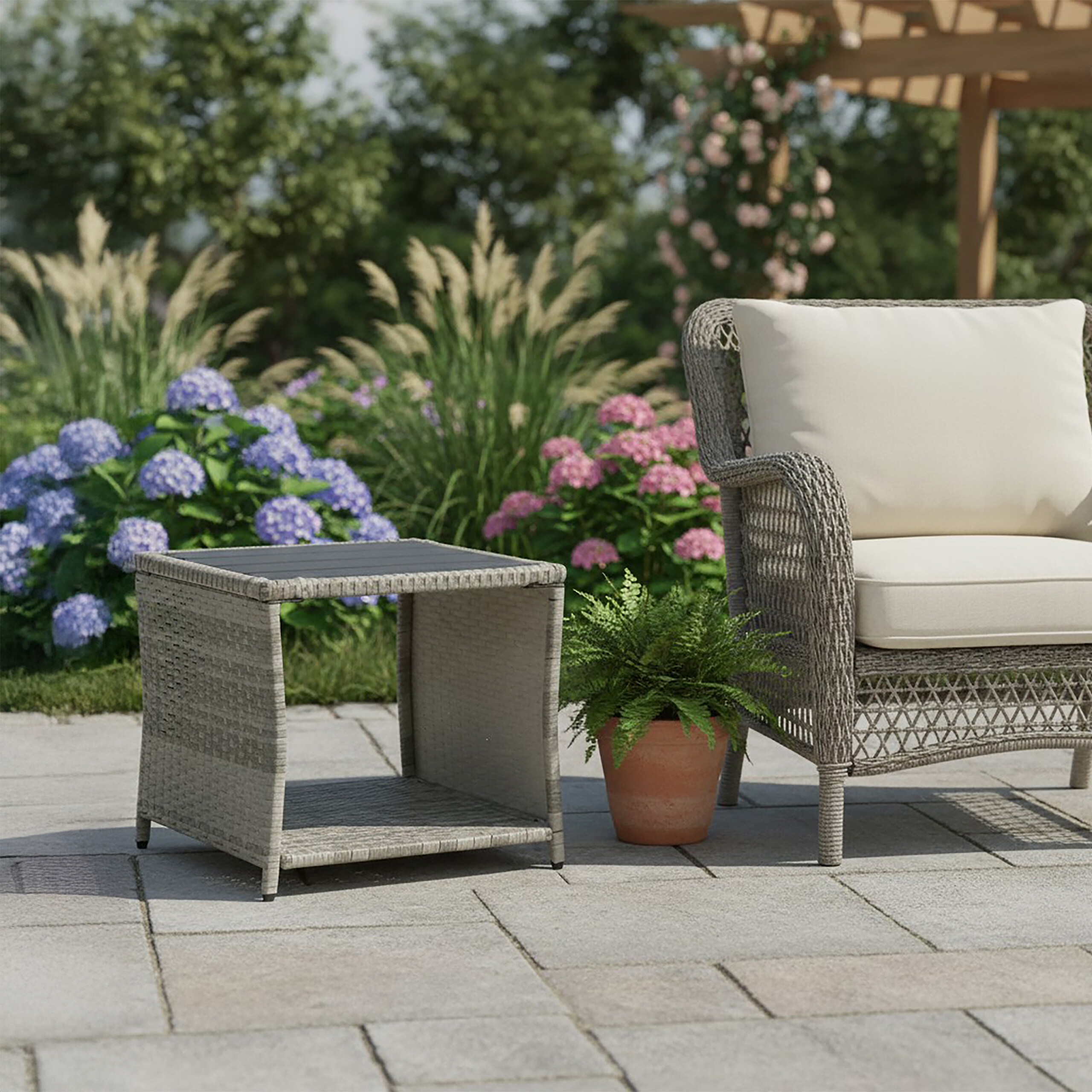 Wicker-Sessel und Beistelltisch auf Terrasse mit Blumen.