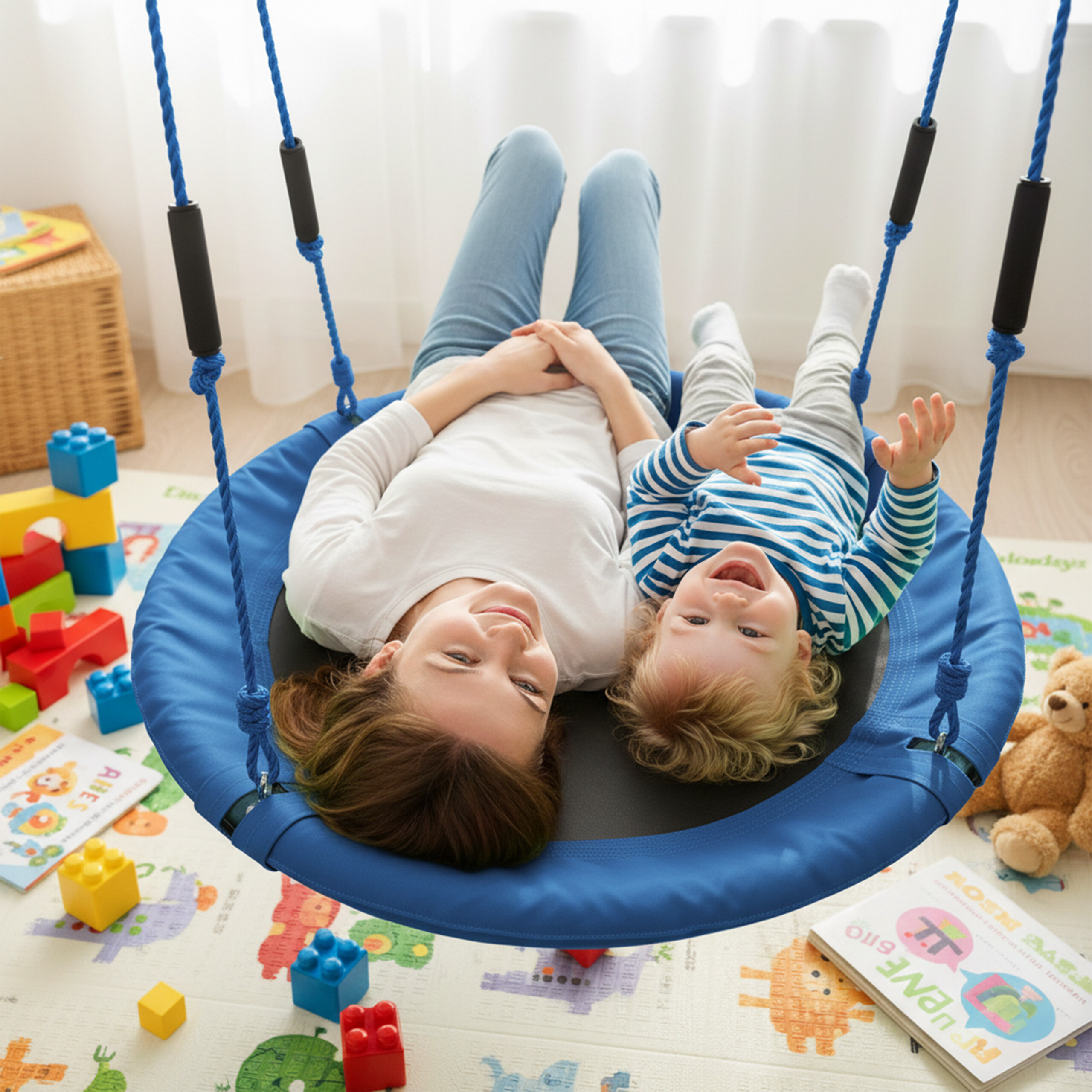 Mutter und Kind liegen auf einer runden Schaukel in einem bunten Spielzimmer.