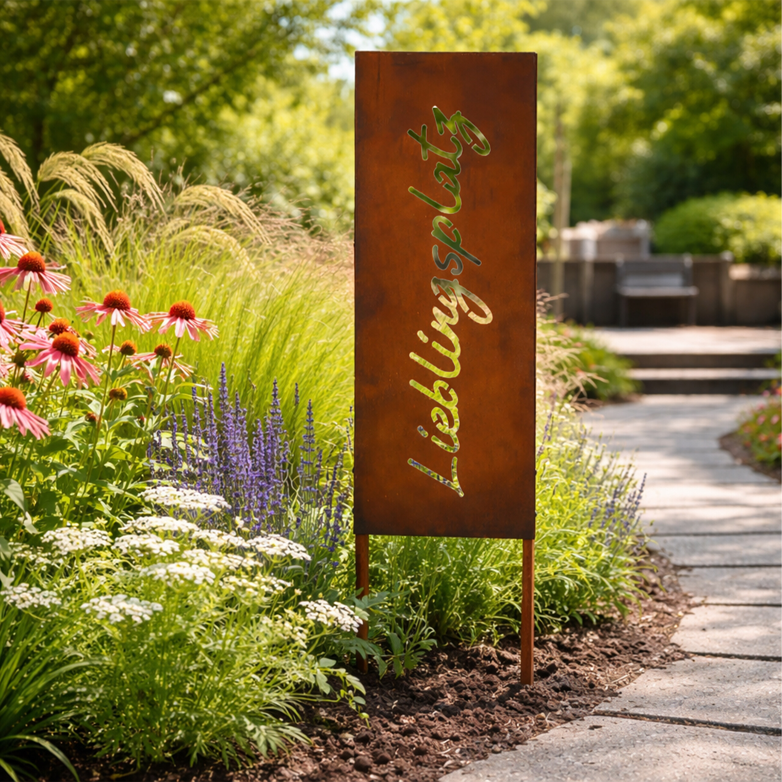 Ein rostiges Metallschild mit der Aufschrift 'Lieblingsplatz' steht in einem Garten mit bunten Blumen und einem Steinweg.