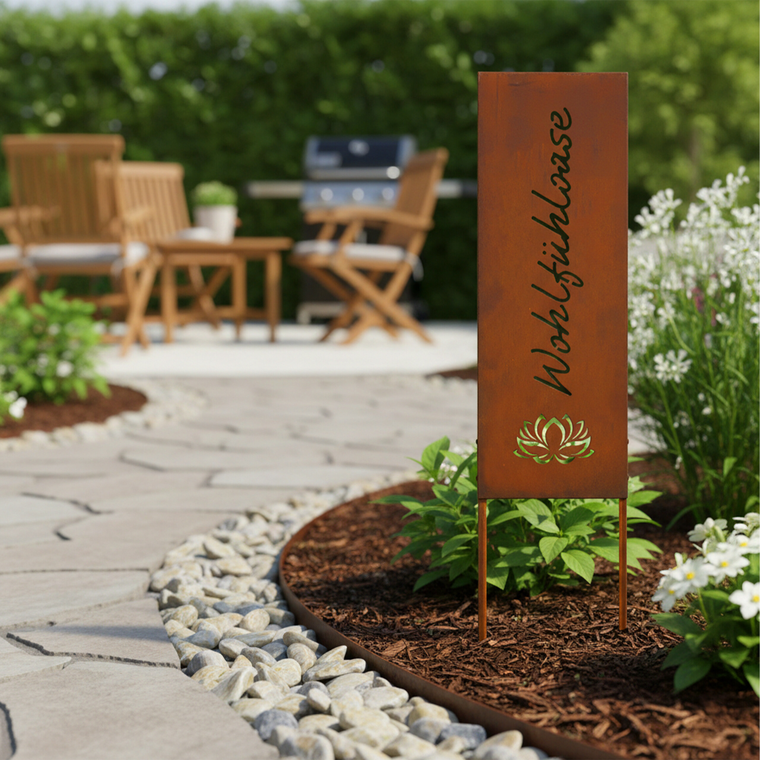 Rostfarbene Gartensäule mit dem Schriftzug Wohlfühloase in einem Blumenbeet am Steinweg.