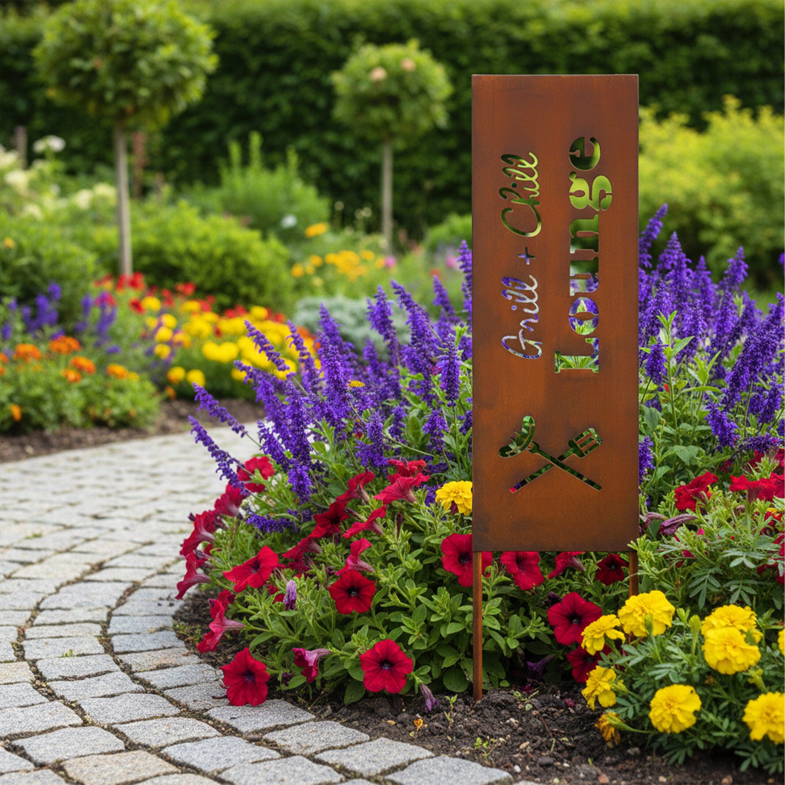 Rostiges Gartenschild mit der Aufschrift Grill + Chill Lounge neben Blumen und einem gepflasterten Weg.