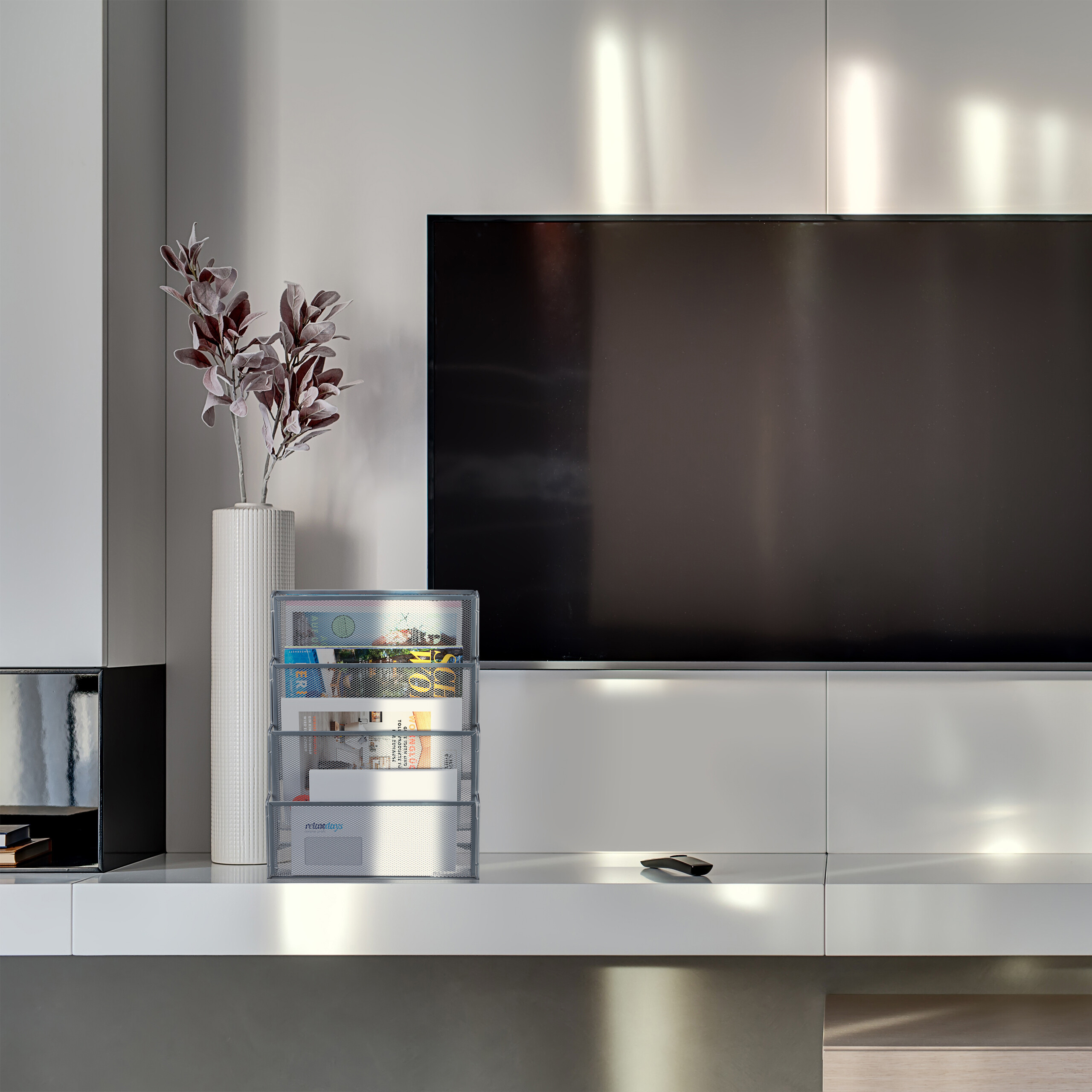 Moderner Fernseher an weißer Wand mit Vasen und Dokumentenhalter auf einem Regal.