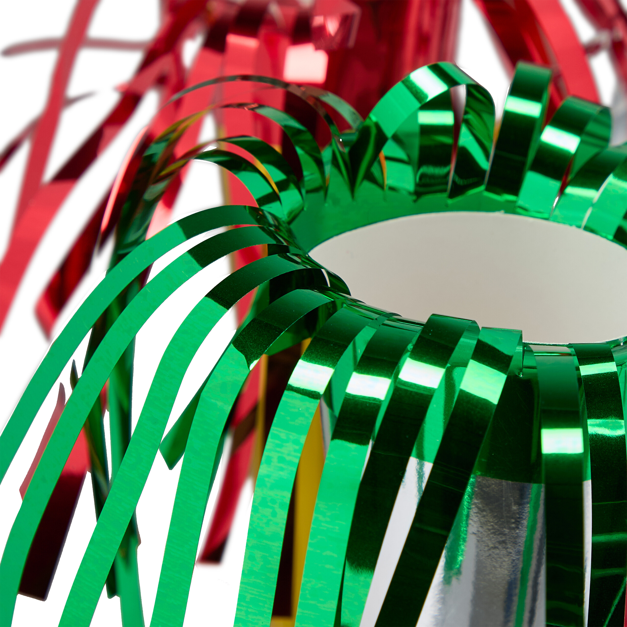 Glänzende grüne und rote Geschenkbandkränze vor weißem Hintergrund.