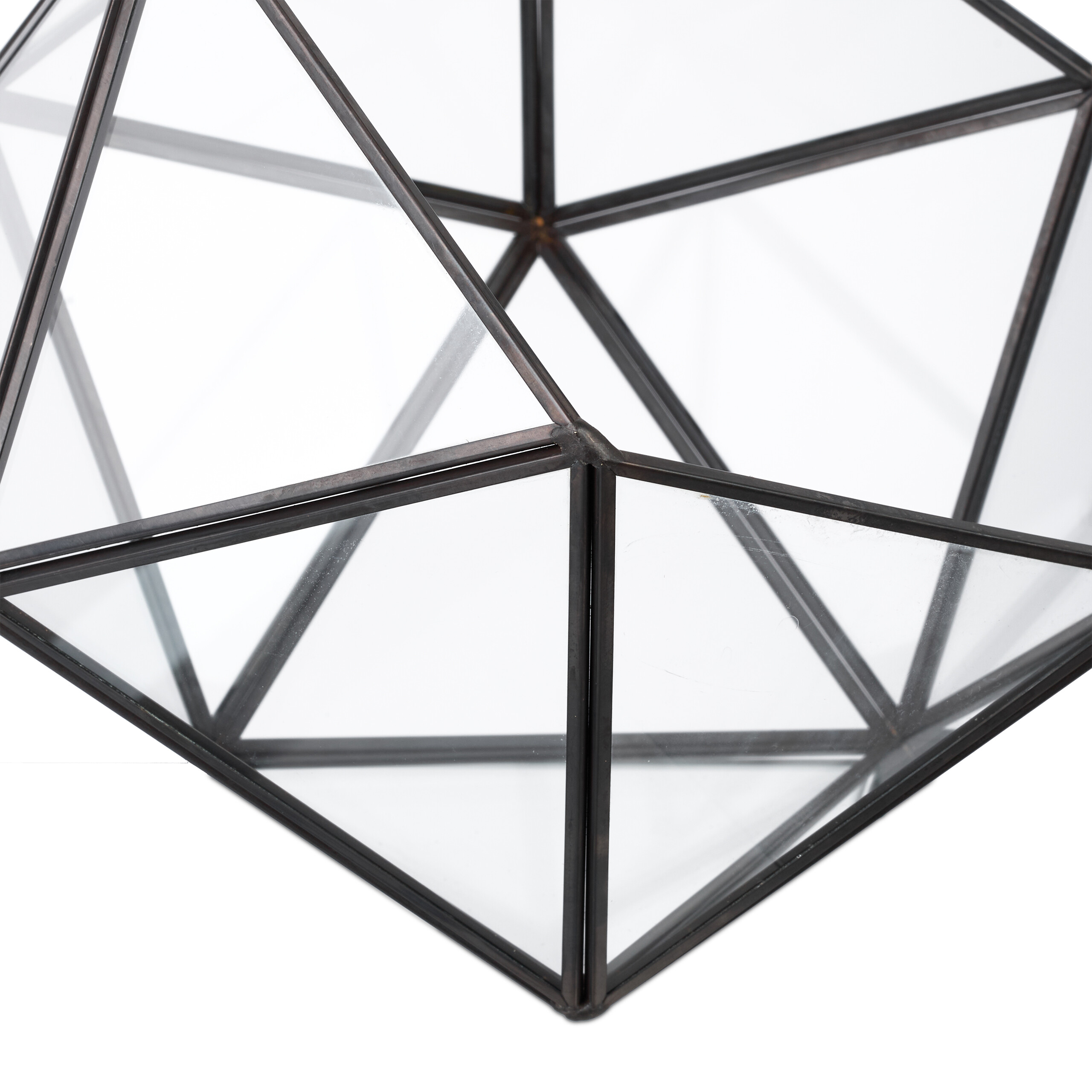 Ein geometrischer Glasbehälter mit schwarzem Metallrahmen vor weißem Hintergrund.