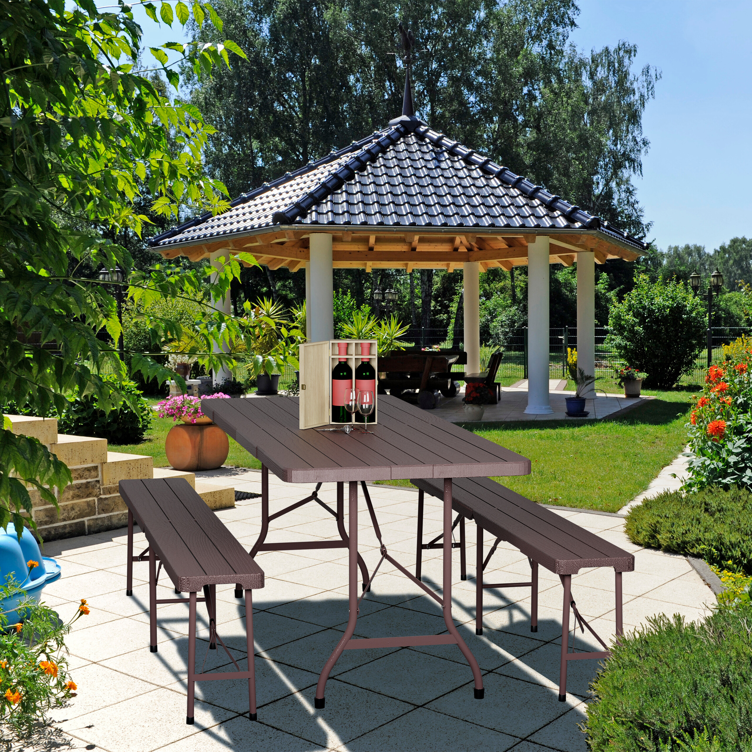 Ein Holztisch mit Bänken auf einer Terrasse, im Hintergrund ein Gartenpavillon.
