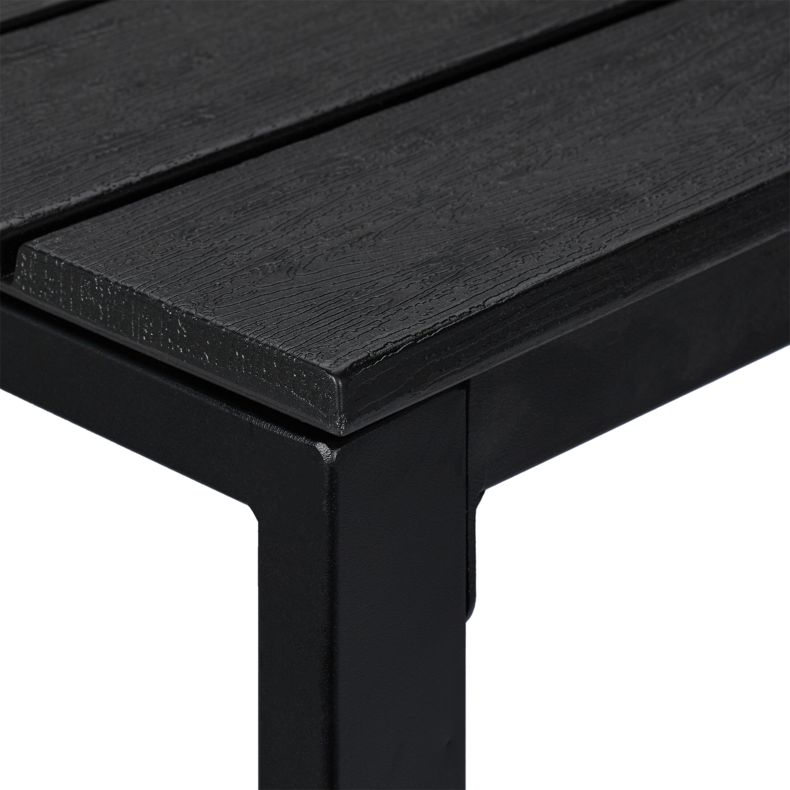 Nahaufnahme einer schwarzen Tischplatte mit Holzmaserung und Metallbein.