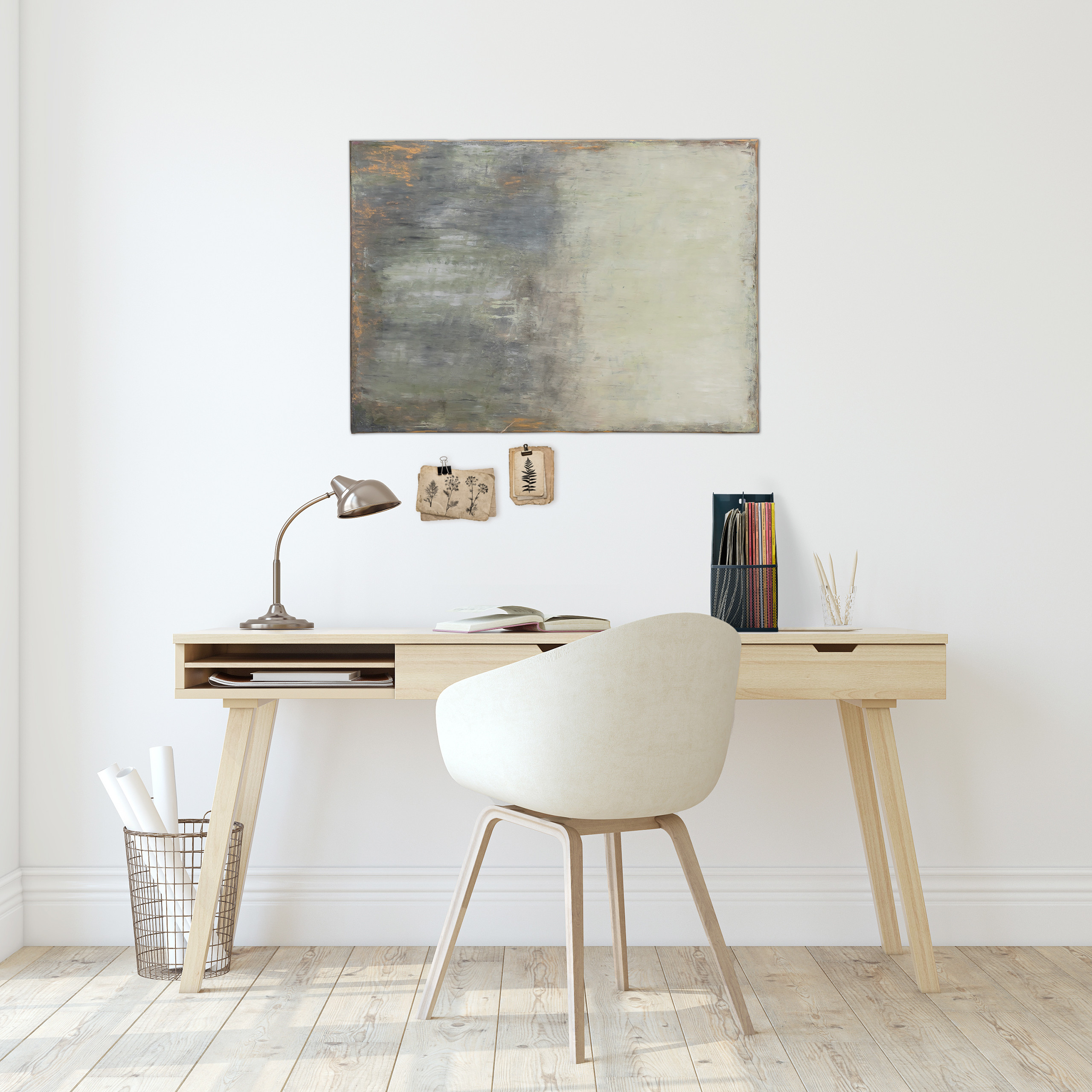 Ein minimalistischer Arbeitsbereich mit Holztisch, weißem Stuhl, Lampe, Kunstwerk und Wanddeko vor weißer Wand.