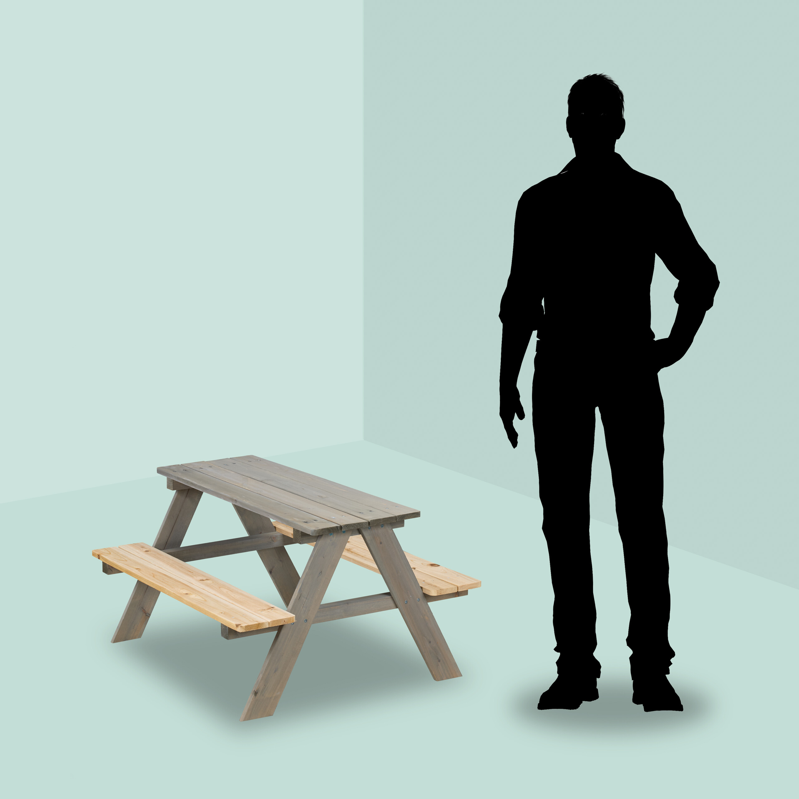 Eine Holzsitzgruppe steht auf einer grünlichen Fläche neben einer menschlichen Silhouette.