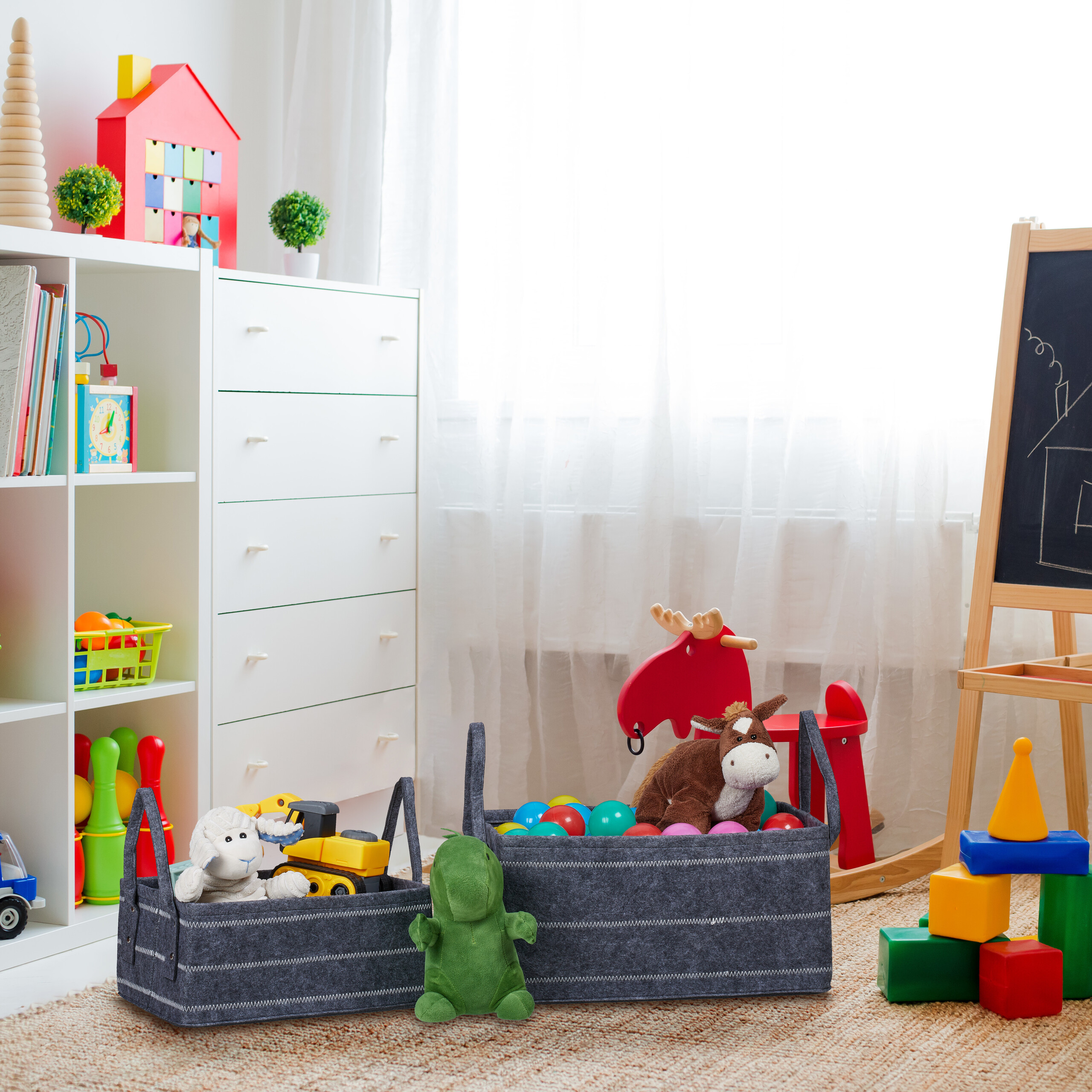 Ein helles Kinderzimmer mit weißem Regal, Spielzeugkörben, Holztafel und bunten Blöcken.