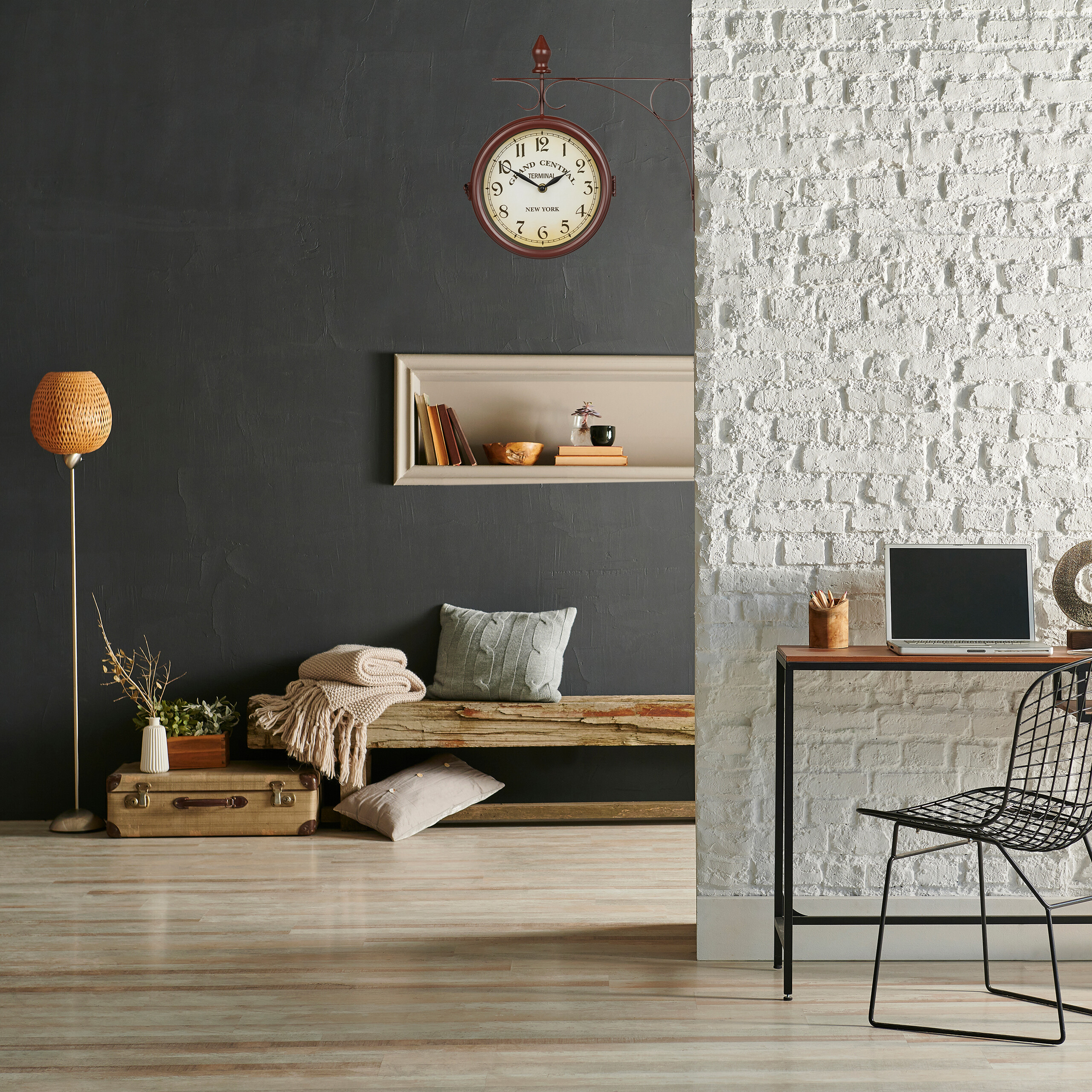 Moderne Raumgestaltung mit dunkler Wand, weißer Backsteinwand, Hängeuhr, Holzsitzbank und Schreibtisch mit Laptop.