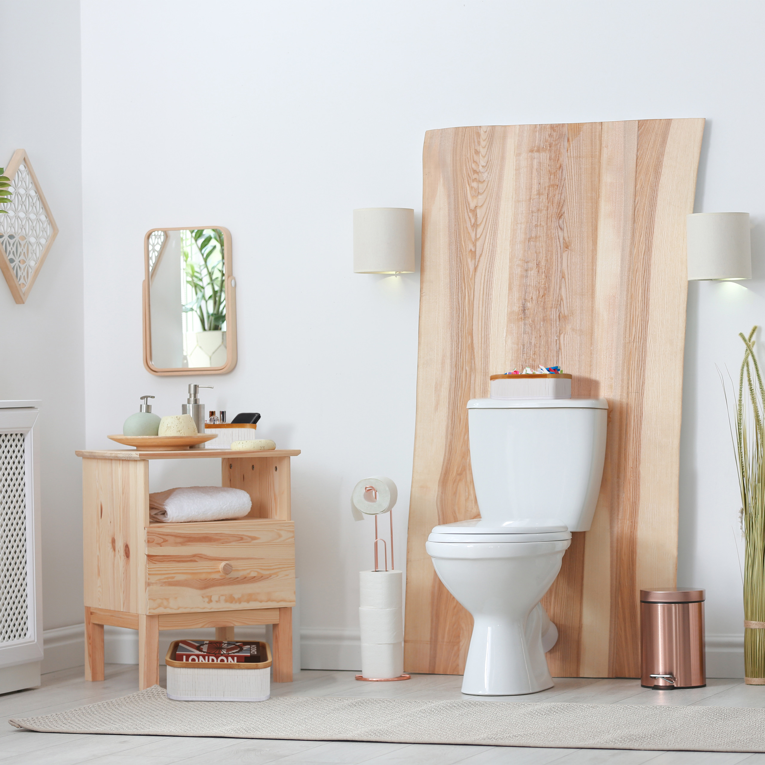 Moderne weiße Toilette vor einer großen Holzplatte, daneben Holzmöbel mit Waschbecken und Spiegel.
