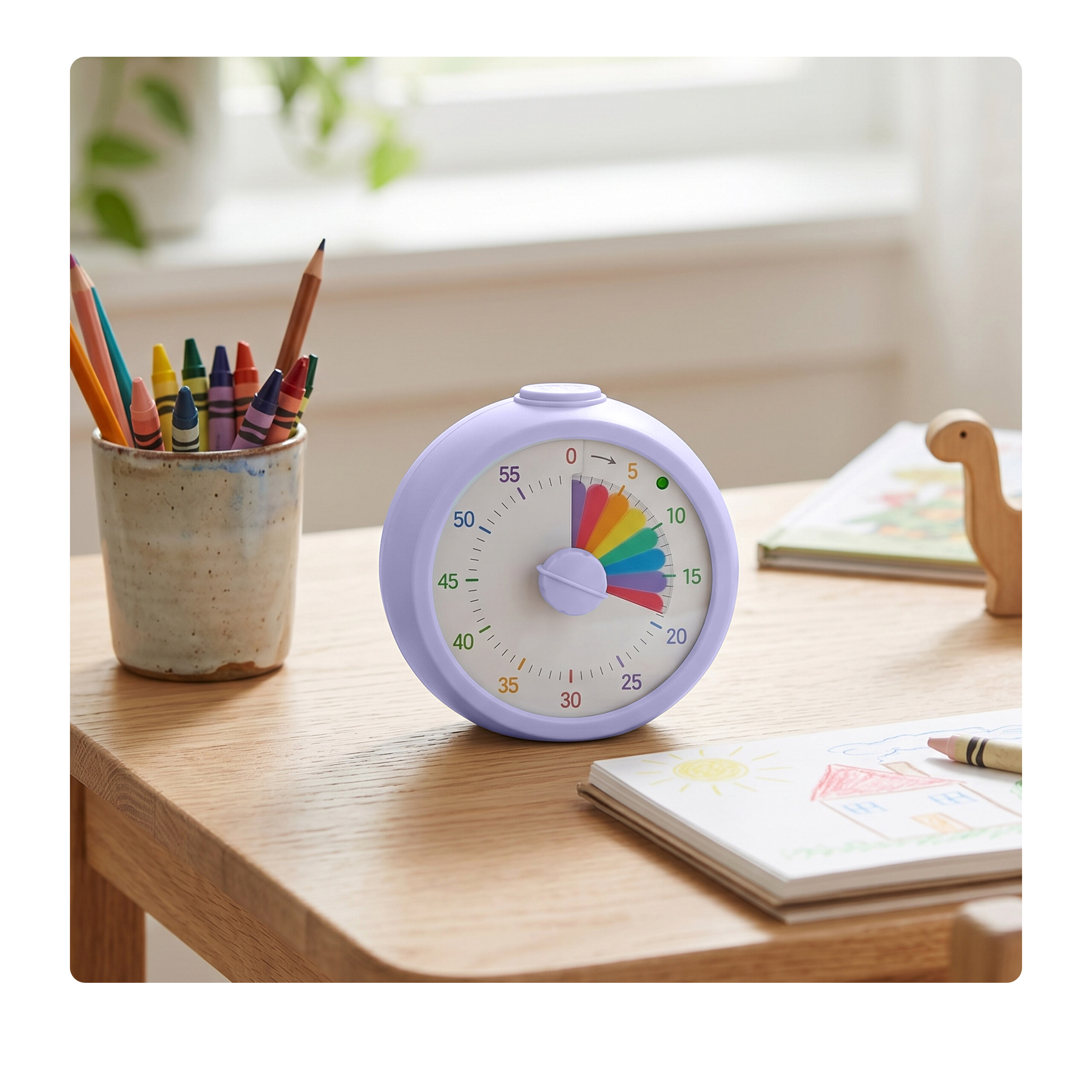 Ein lila Timer steht auf einem Holztisch, neben Buntstiften in einem Becher und einem Zeichenblock.