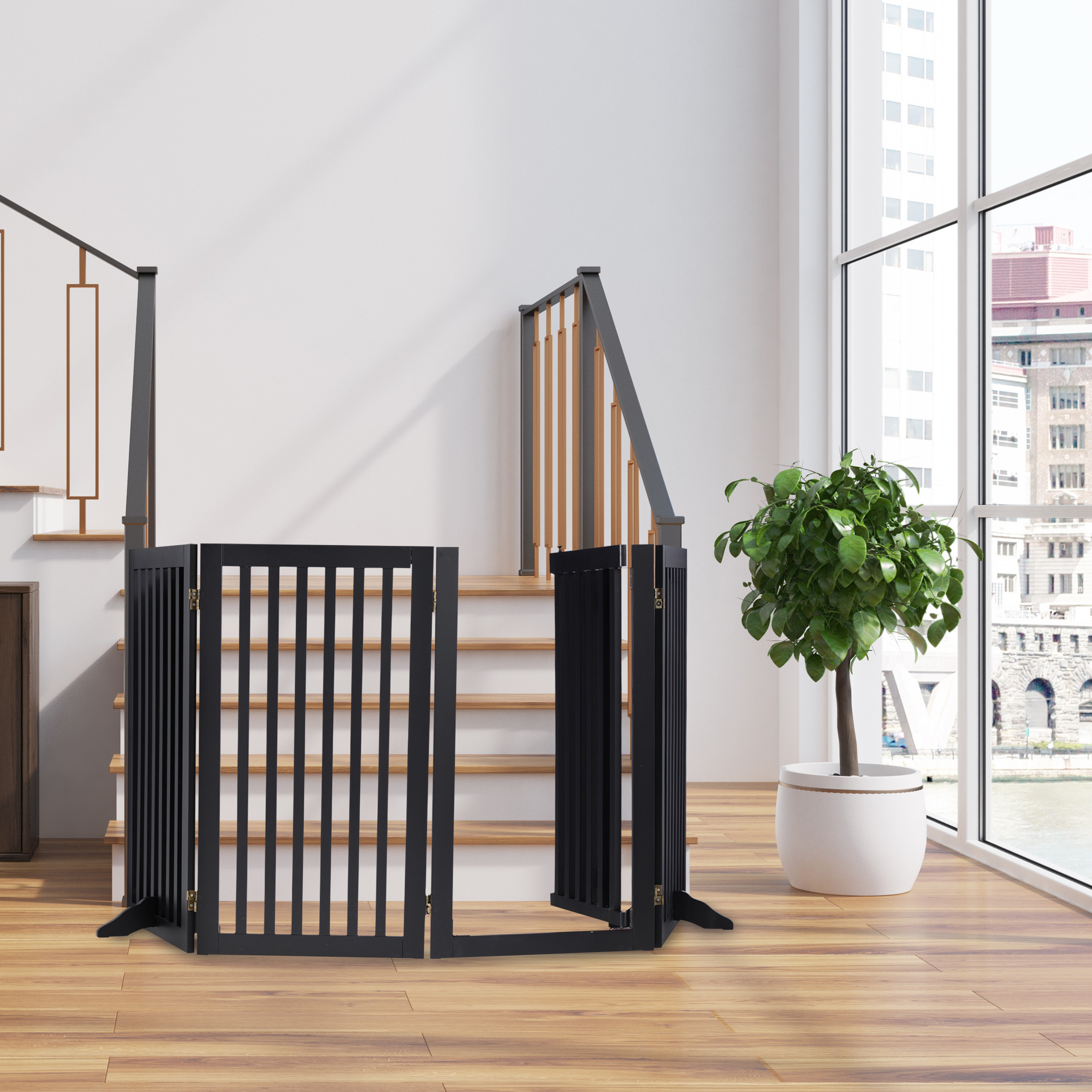 Ein schwarzes Babygitter steht am Fuß einer Holztreppe vor einer großen Fensterfront mit Blick auf Gebäude.