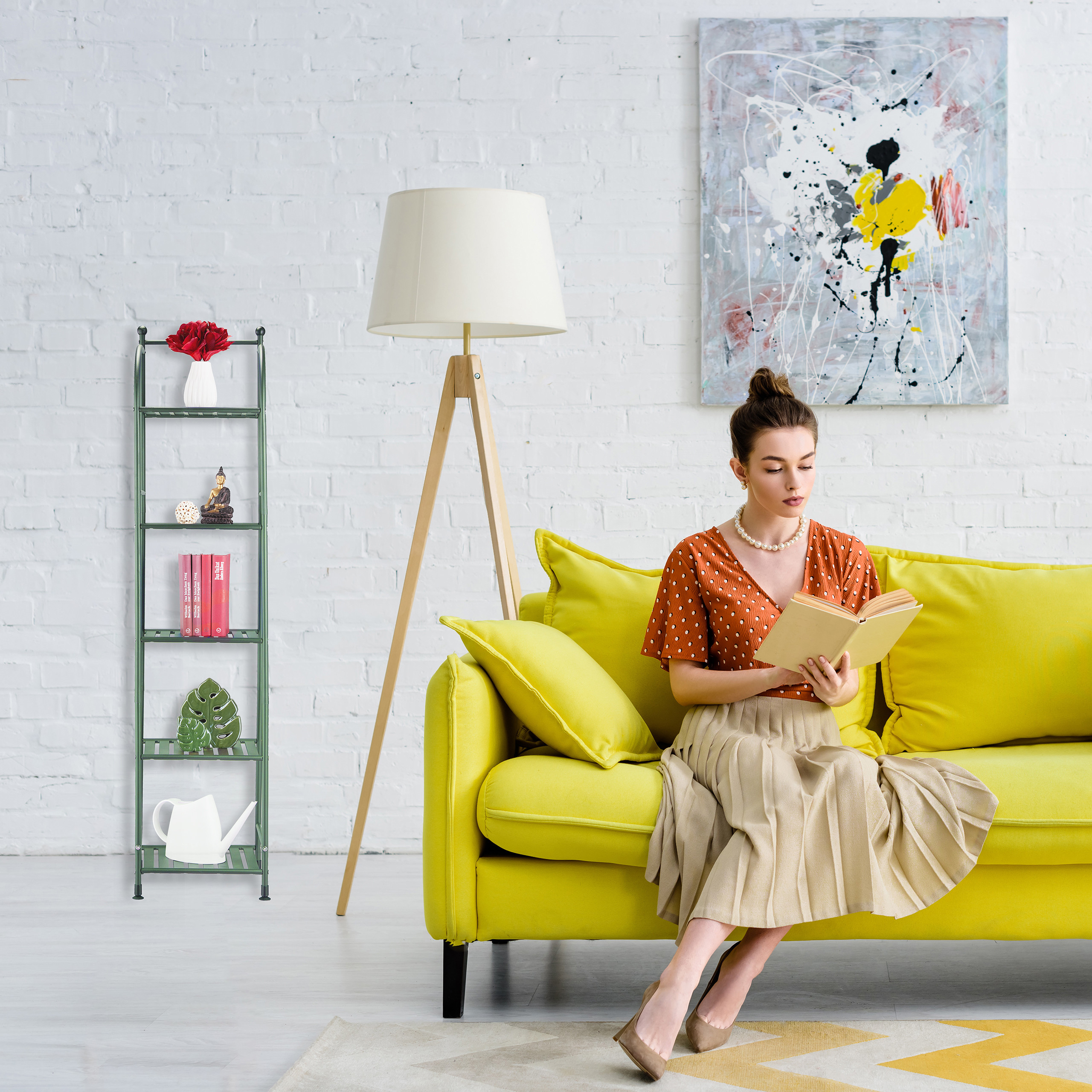 Eine Frau liest ein Buch auf einem hellgelben Sofa in einem Raum mit weißer Backsteinwand.
