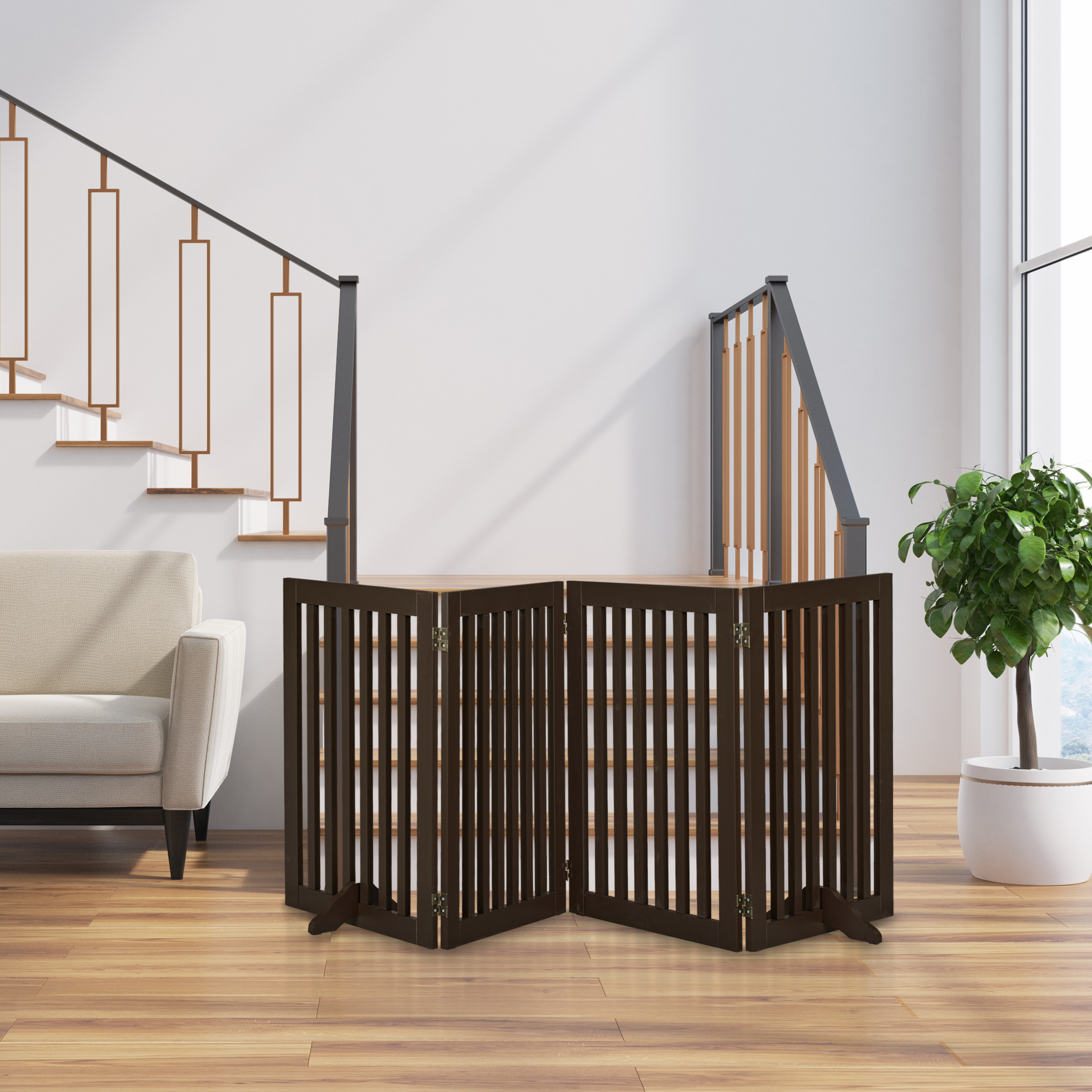 Ein braunes Holz-Haustiergitter steht auf Holzboden neben Sofa, Treppe und Topfpflanze.