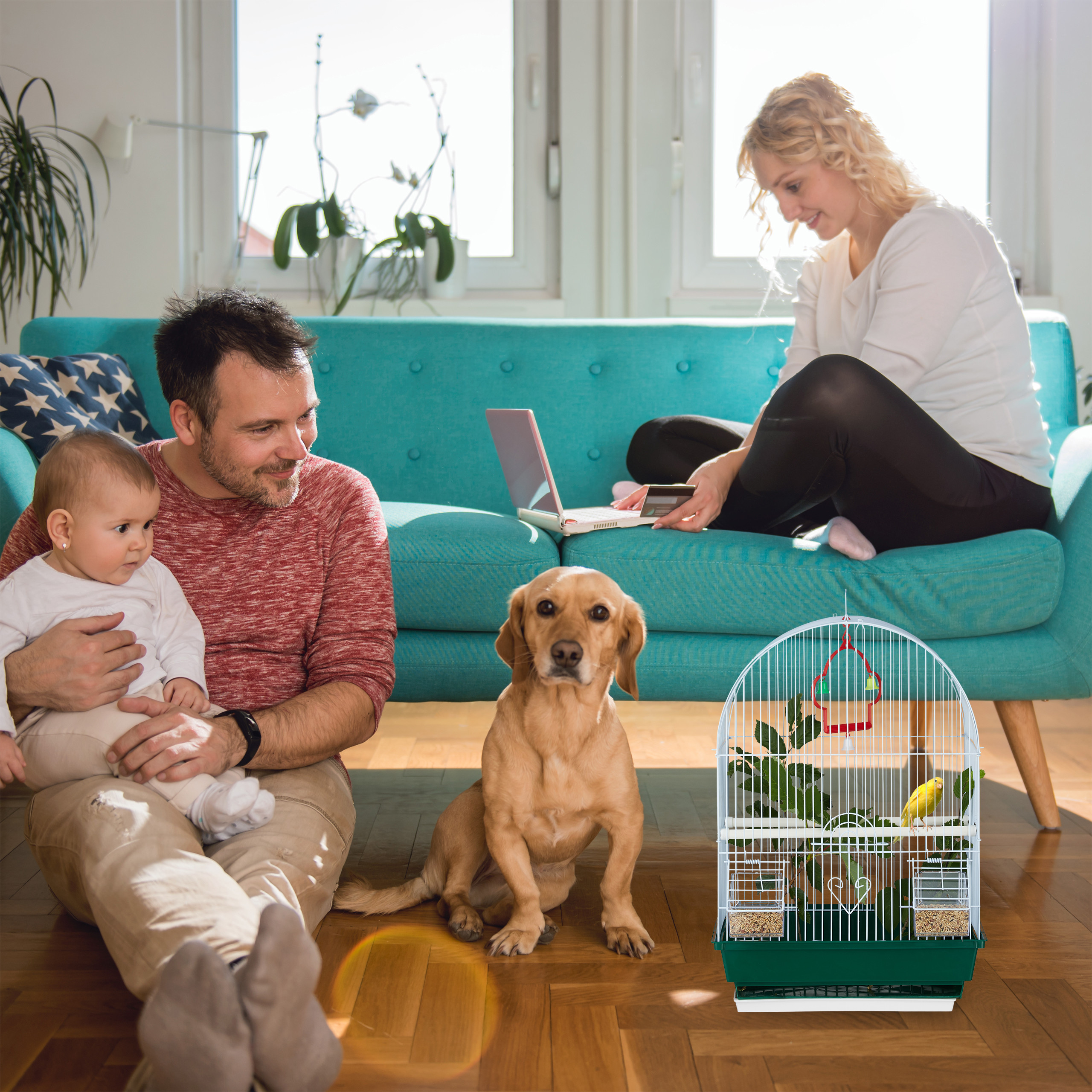 Eine Familie mit Hund und Vogelkäfig im Wohnzimmer auf dem Boden.