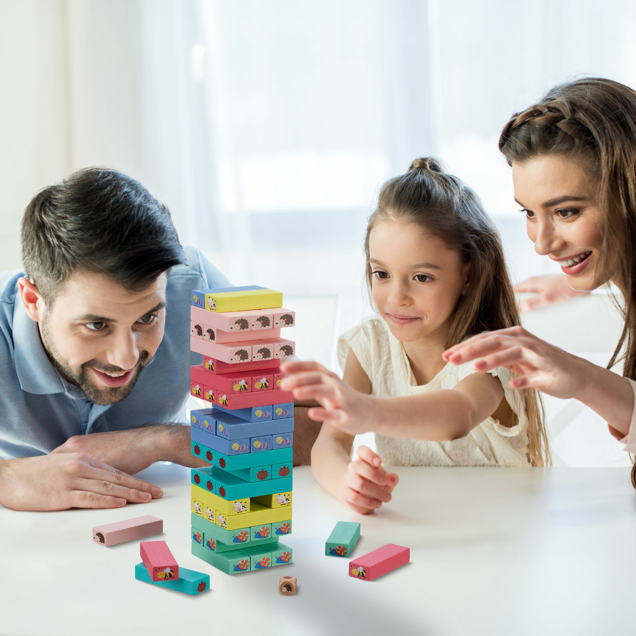 Eine Familie spielt zusammen ein buntes Holzklötzchenspiel am Tisch.